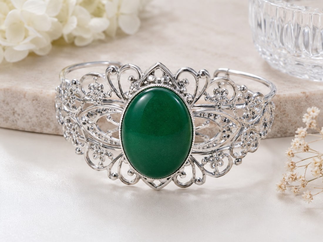 Green Cabochon Silver Tone Filigree Cuff Bracelet: Title: Green Cabochon Silver Tone Filigree Cuff Bracelet Description: Beautiful open cuff bracelet featuring a large oval green cabochon stone, surrounded by intricate silver-tone floral and scroll
