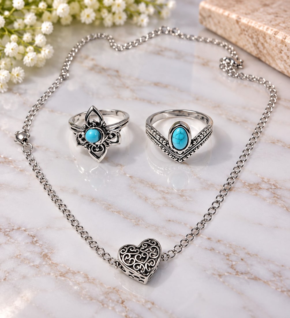 Silver-Tone Heart Necklace & Two Turquoise-Style Rings: Title: Silver-Tone Heart Necklace & Two Turquoise-Style Rings Description: A decorative jewellery set comprising a silver-tone chain necklace with an ornate filigree heart pendant and two rings