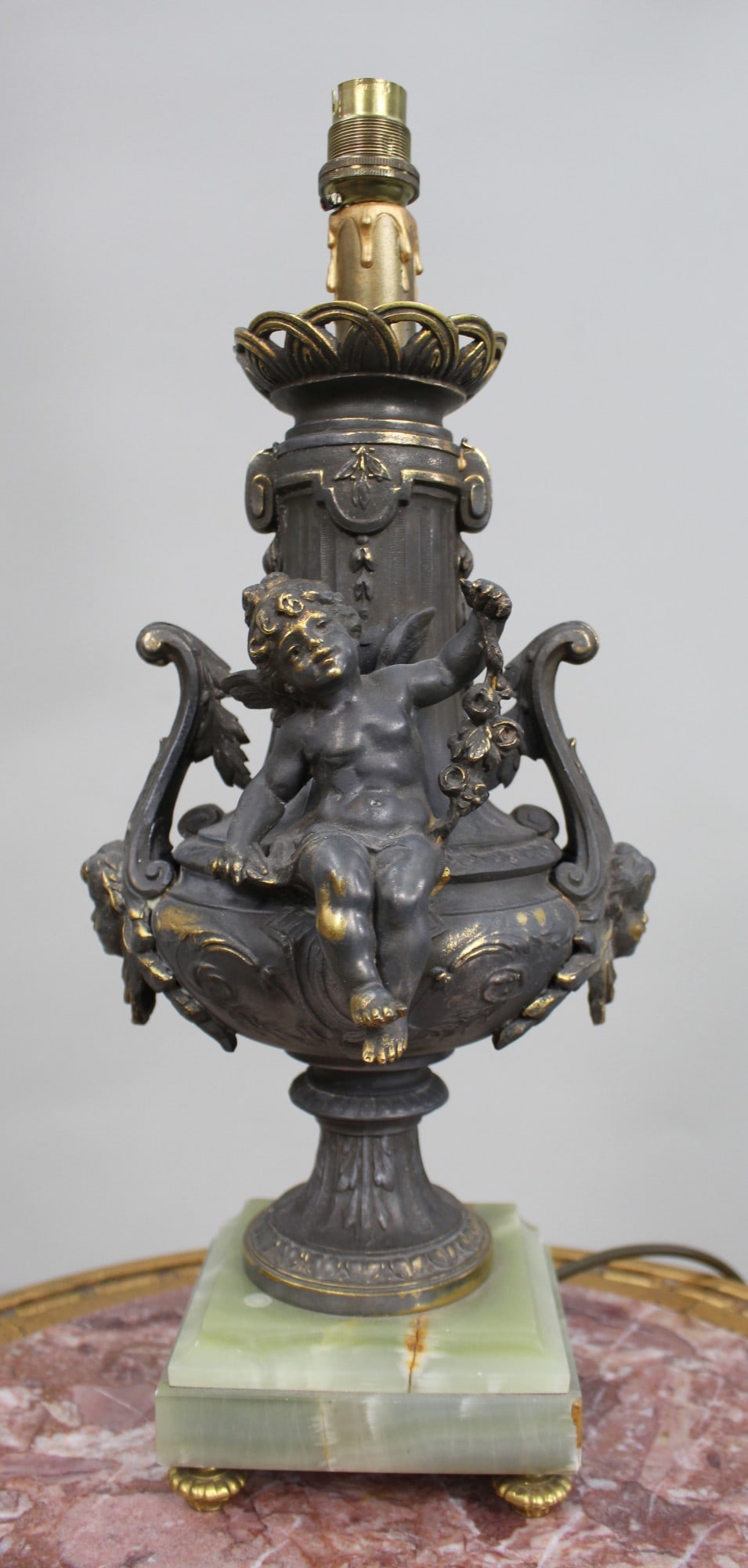 Vintage Gilt Brass Cherub Onyx Table Lamp: Title: Vintage Gilt Brass Cherub Onyx Table Lamp Description: Vintage Gilt Brass Cherub Table Lamp on Onyx Base, modelled as a classical urn with seated cherub, scrolling handles and decorative mas