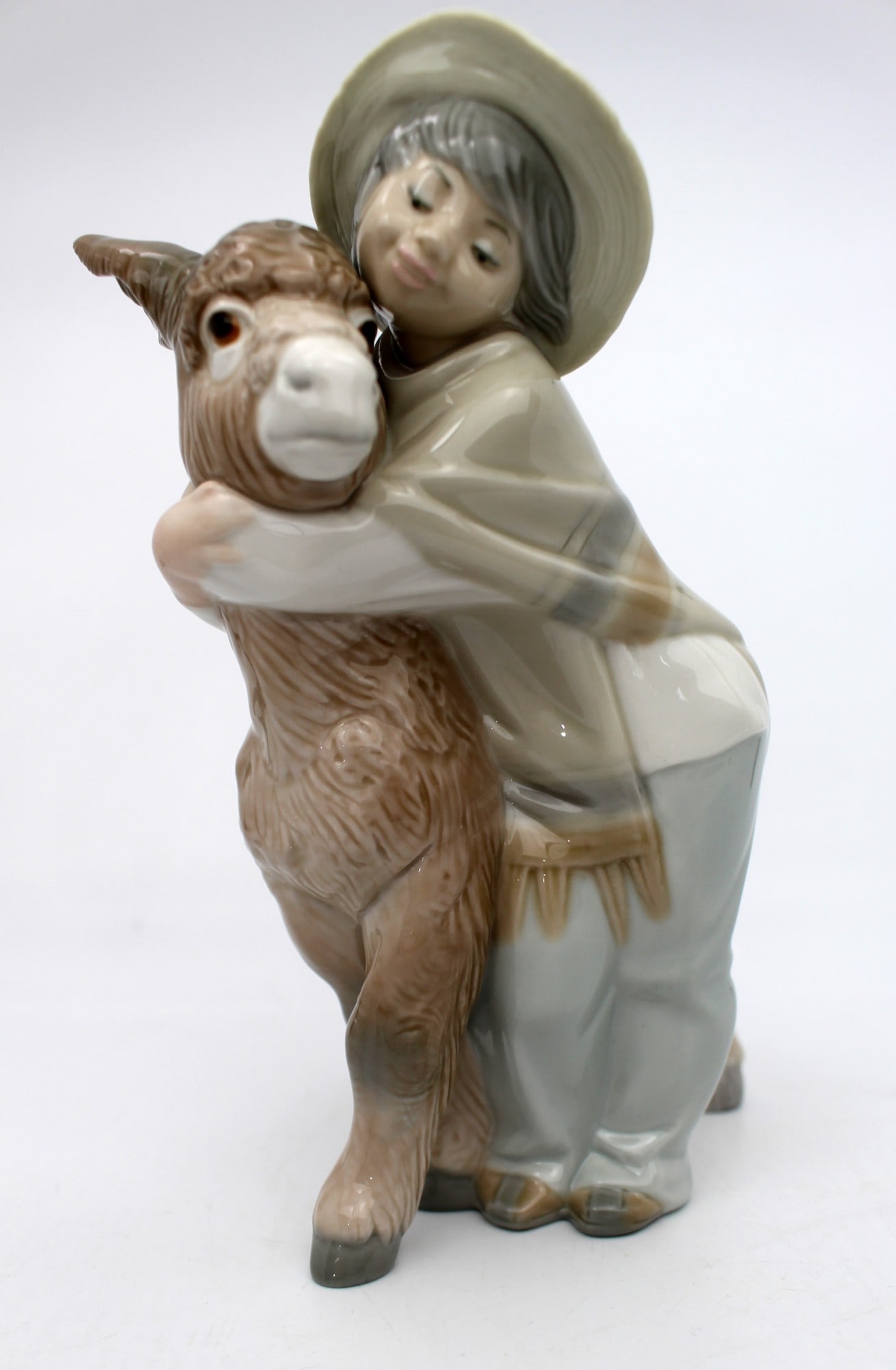 Lladro Boy Hugging Donkey: Title: Lladro Boy Hugging Donkey Description: Lladro Boy Hugging Donkey Measures 15 x 10 x 21 (height) cm. Very good condition; no chips, cracks or repairs. Condition: Used Delivery option: