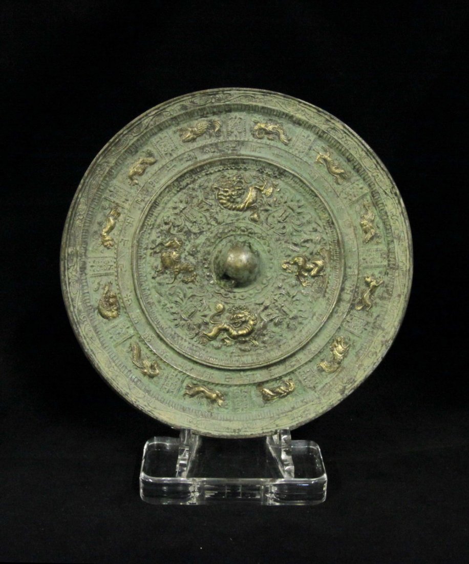 Han Dynasty Gilt-Bronze Mirror: Measuremnet: Dia. 8.75 in., Thickness 0.375 in. This was a well cast with the central knob, encircled by gild dragon, phoenix and mythical animals with a band of inscription, the outer field with twel