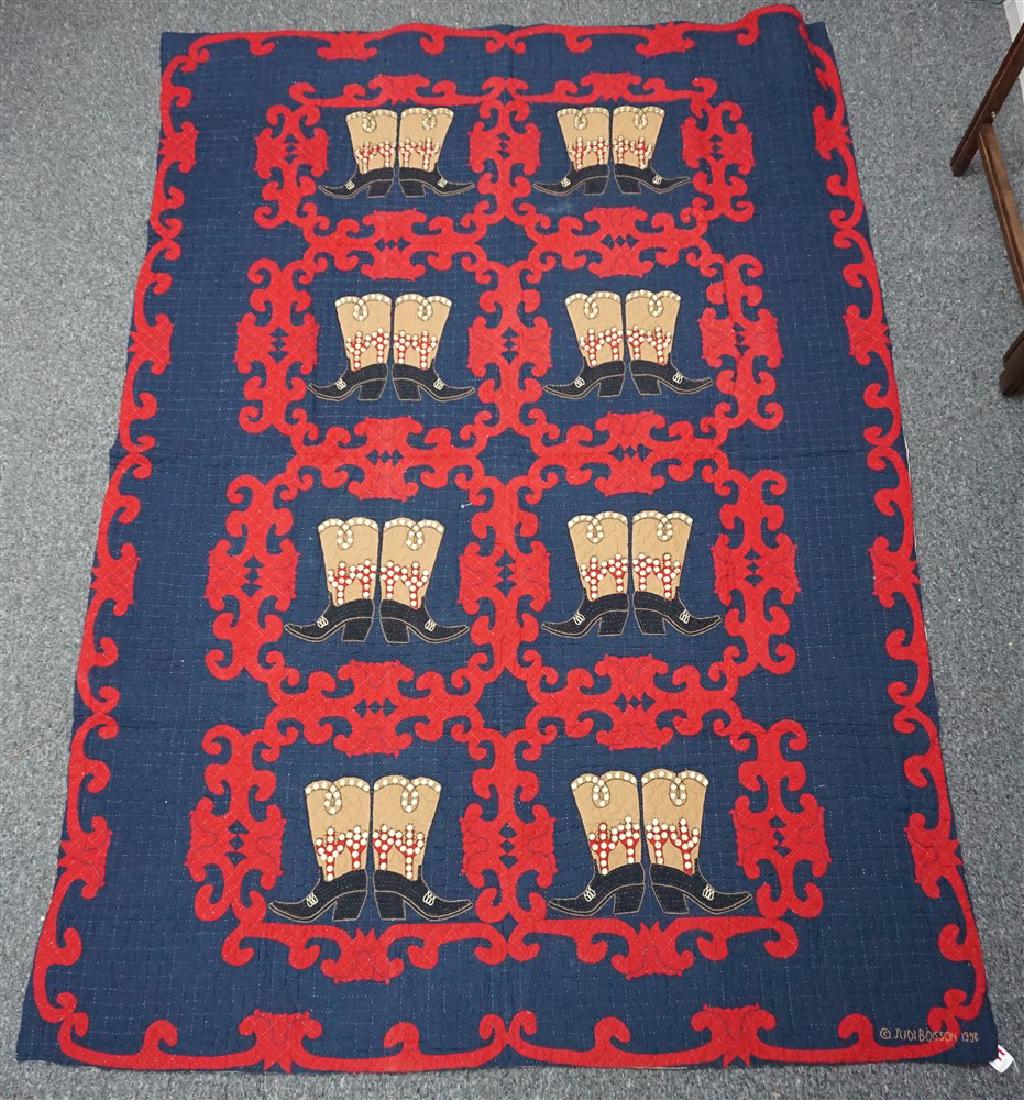 JUDI BOISSON BIG BOOTS TWIN QUILT: Judi Boisson "Big Boots" Quilt in Navy-Crimson with Rivets. With Crimson Scrollwork and Saddle & Black Boots with Rivets. Hand Appliqued and Quilted. Signed. Twin size 64"x85". Very Good Condition. Cu
