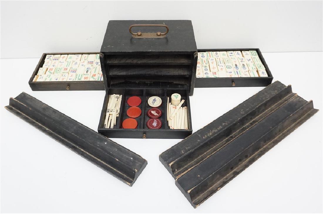 VINTAGE 1920s MAHJONG SET: Vintage 1920s Mahjong Set in a 3-drawer wooden case. 144 Tiles. Polychrome Bone with Bamboo Wood Backs. Wood Box missing sliding front. Three tile holders. Box 9 1/2"x7"x5 1/2". Wood tile holders 16" 