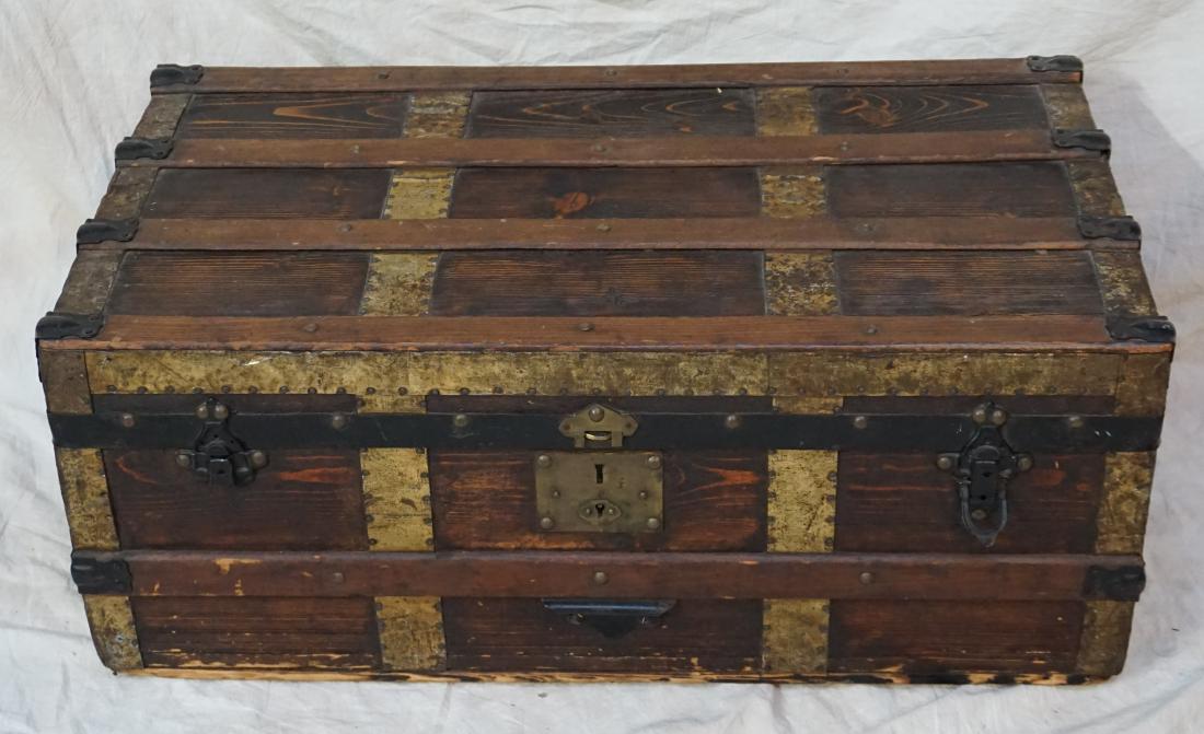 ANTIQUE WOOD STEAMER TRUNK: Antique Wood Steamer Trunk. Brass and Iron Bound Flat Top Trunk 19th c. Measures 32x18x13". Hinge Broken. PROVENANCE: A Pawleys Island SC Private Estate. *Pickup only or Shipping on furniture offered 