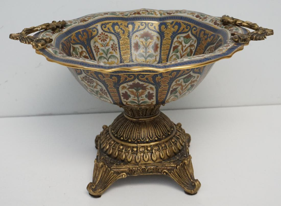 ORMOLU MOUNTED PORCELAIN BOWL: Vintage Ormolu Mounted Porcelain Bowl / Centerpiece in the French Style. The bowl is porcelain with the foot and handles composite that is painted in a bronzed gilt. The bowl is floral with gilt accen