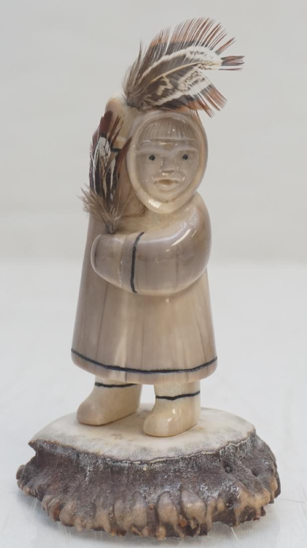 EDDY SYNGOC CARVED FOSSIL WALRUS: Fossil Walrus Inuit Dancer with Feathers carved by Inuit artist, Eddy Syngoc of Alaska. Signed under the base by the artist, carved in 1989. Great details. Measures 2 3.4"x2 1/4"x4 1/2". Weight 5.8 oz