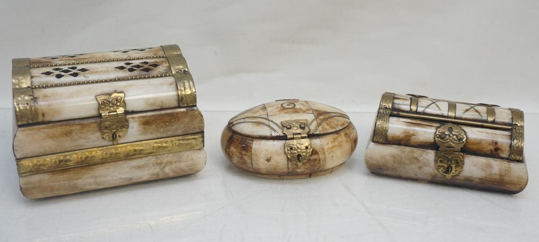 3 MIDDLE EASTERN CAMEL BONE TRINKET BOXES: 2 Middle Eastern Camel bone trinket boxes. With Brass inlay and hardware. Lined interiors. Largest 4 1/2"x3 3/4"x3". Middle 3 3/4"x2 1/2"x 1 3/4". Smallest Oval 3 3/4"x 2 3/4"x1 1/2". Weiggt on all 1 