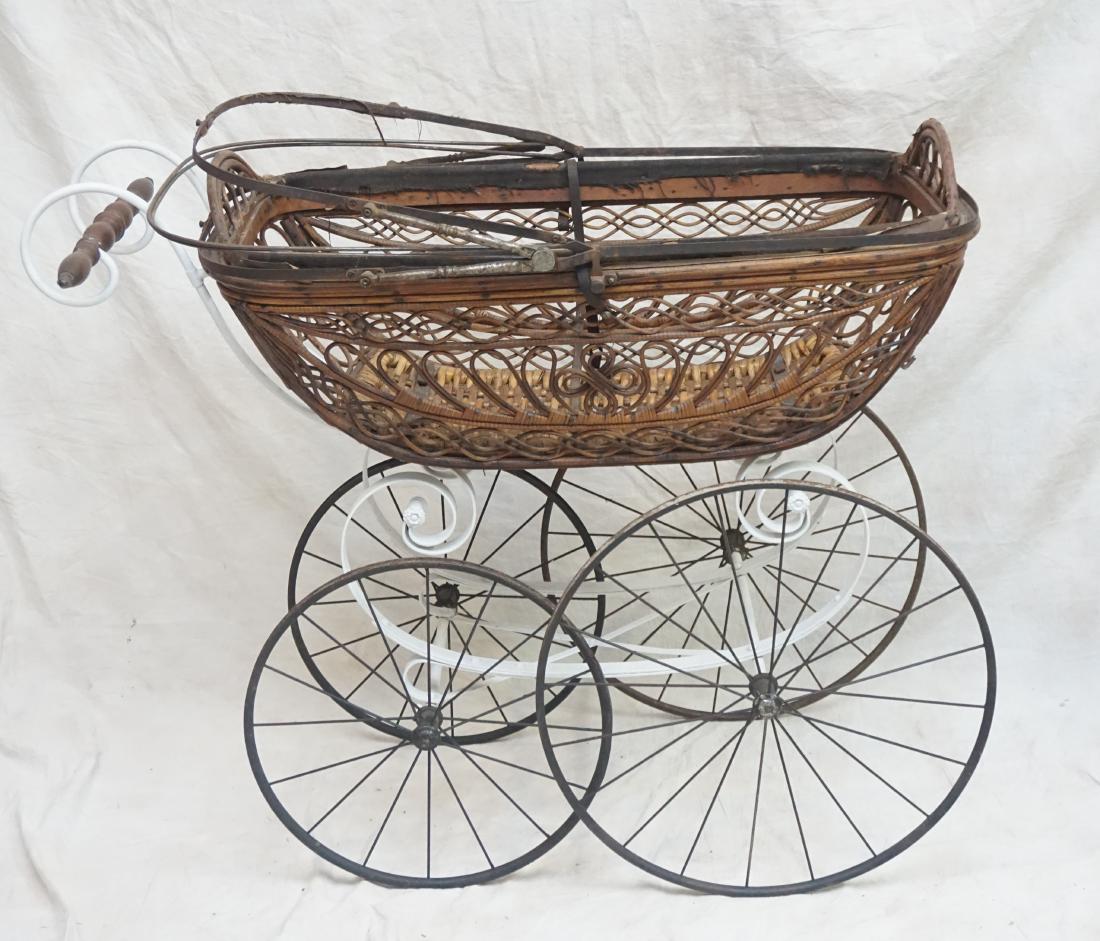 ANTIQUE RATTAN BABY BUGGY: Antique Rattan and Iron Baby Buggy. Wood Wheels. Stamped on the Brass is D.R. Patent No. 57563. Great piece for display. 43" with handle' carriage 36 x 18 x 33" (without top closed) 50.50" with top op