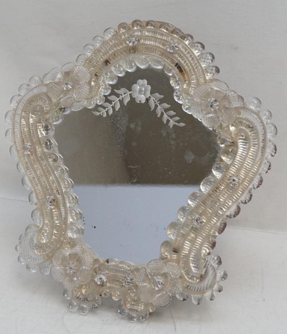 VENETIAN GLASS VANITY MIRROR: Vintage Venetian Vanity Mirror. Glass frame with scalloped rim and flower accents, etched glass mirror and wood easel back. Measures 9"x10". Weight 1 pd 11 oz. PROVENANCE: A Charleston SC Private Esta