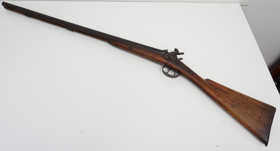 DOUBLE BARREL PERCUSSION SHOTGUN: American 19th century Double Barrel Percussion Shotgun. Muzzle loading black powder, 12 bore, original wooden ramrod. Old repair to trigger guard. Length 48". Weight 12 pds. PROVENANCE: Laurel Hill Pl