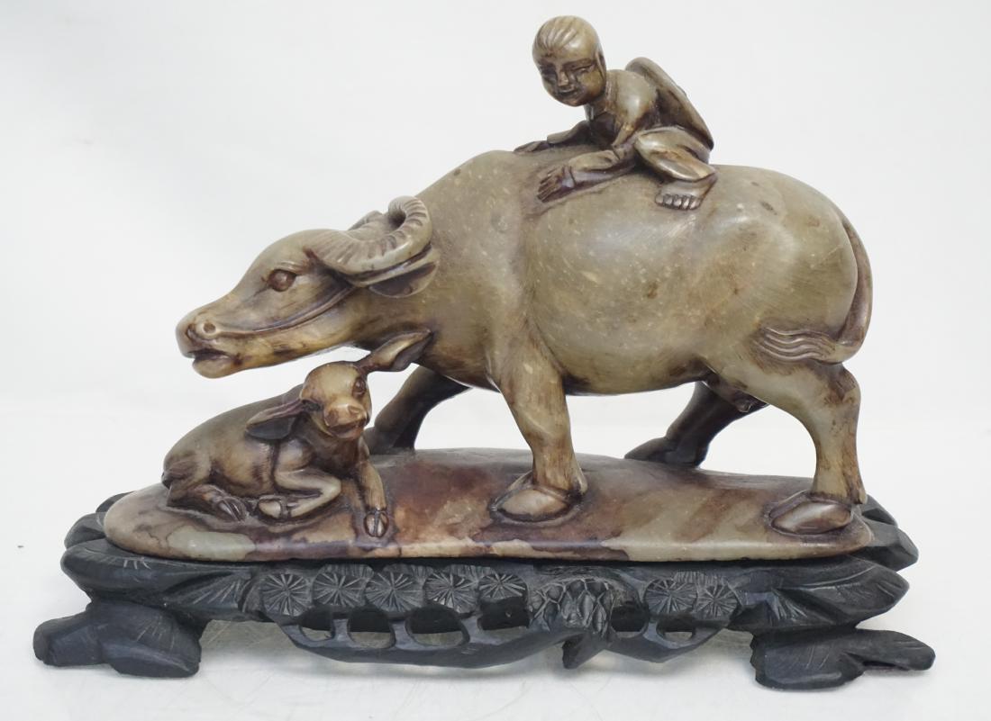 CHINESE CARVED SOAPSTONE WATER BUFFALO GROUP: 20th c. Carved Chinese Soapstone Water Buffalo Figural Group on Ebony Wood Carved Stand. Measures 9 1/2"x4"x7". Weight 4 pds 8 oz. PROVENANCE: A Private Charleston SC Estate.