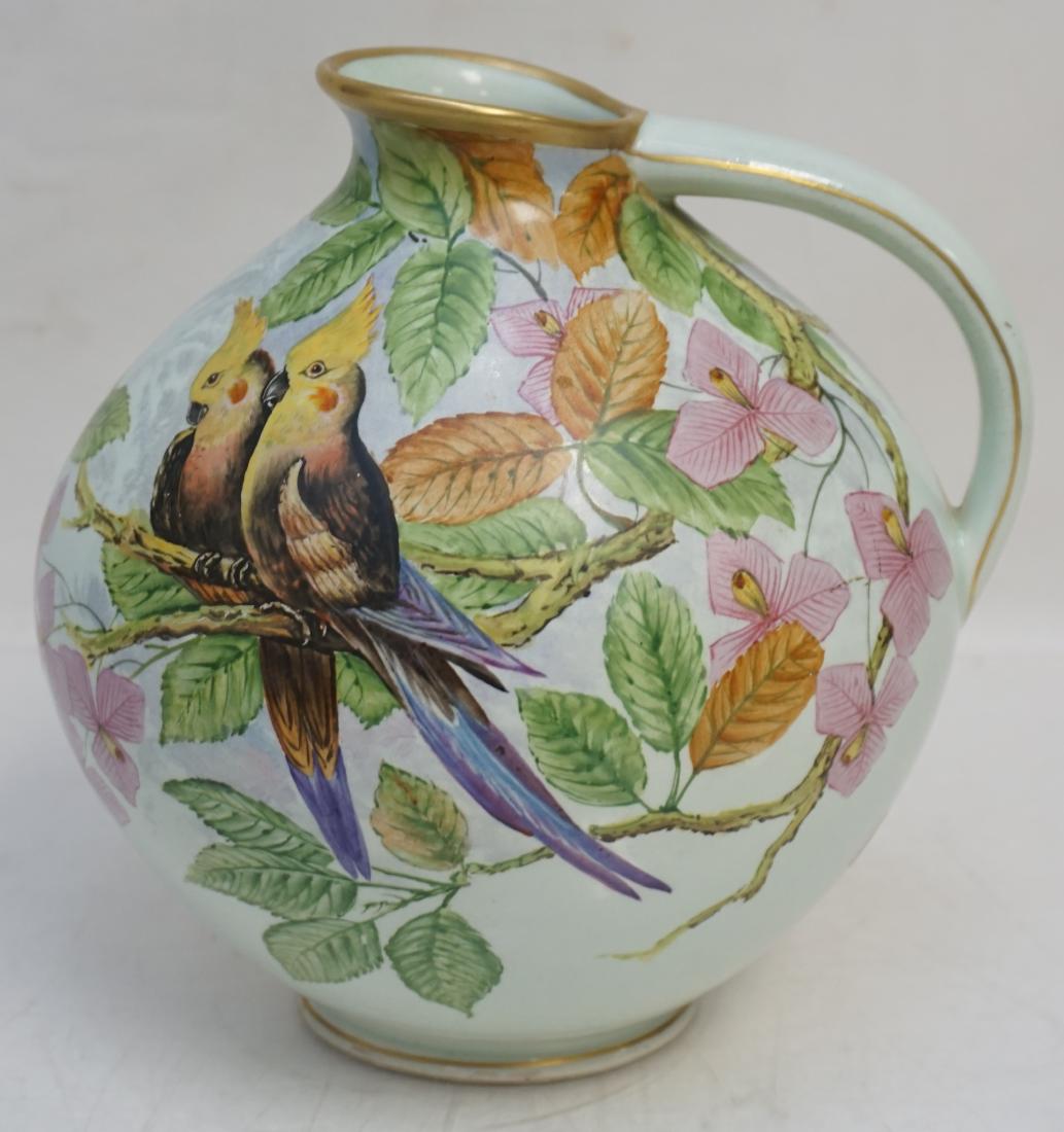 CARSTENS HAND PAINTED COCKATIEL JUG: Antique German Carstens Hand Painted Earthenware Jug. Painted by factory artist Alois Riebl and signed on the bottom. The jug features various flowering trees with a toucan on one side and 2 Cockatiel