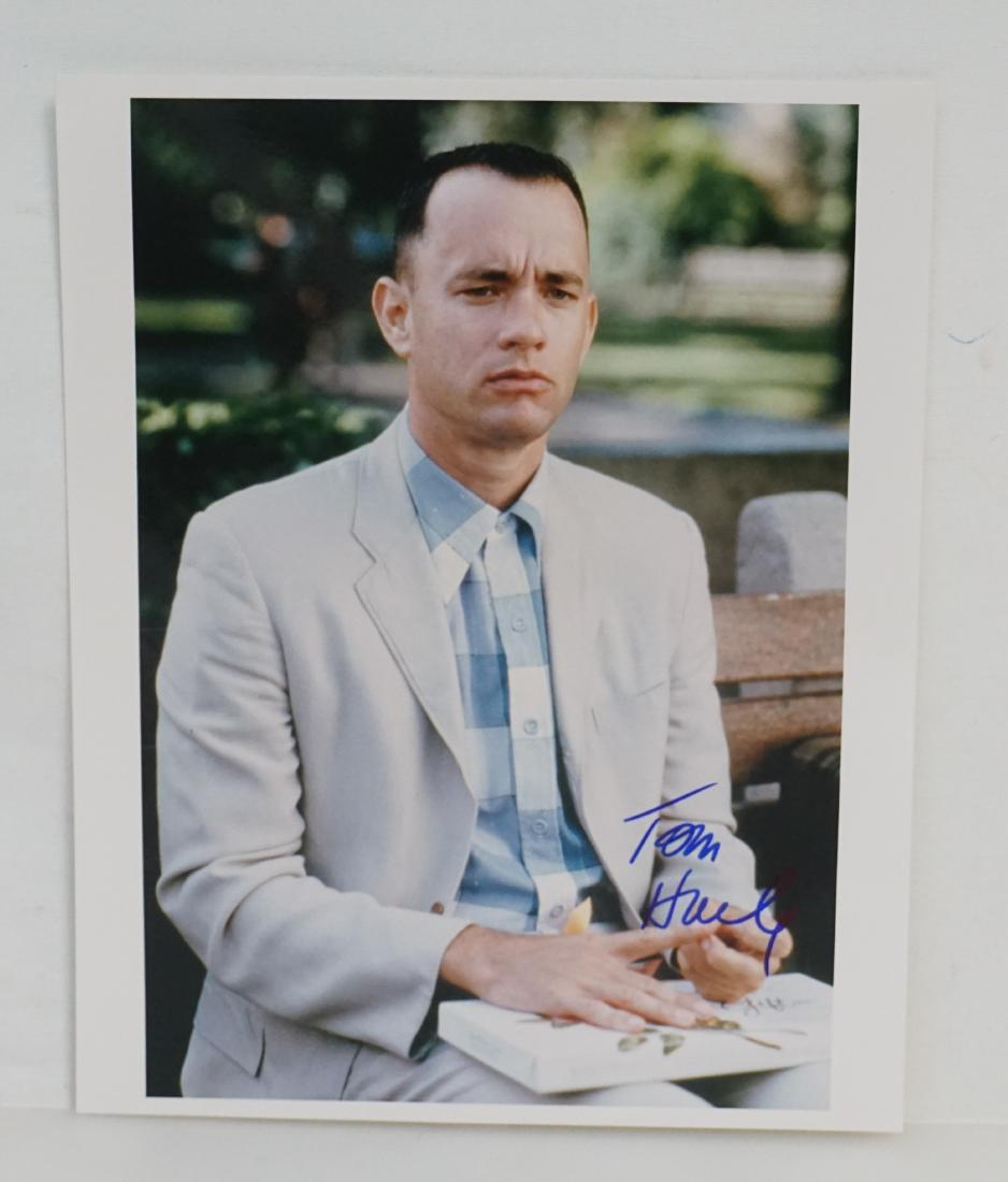 TOM HANKS SIGNED AUTOGRAPH CLASSIC FORREST GUMP BENCH: Classic Forrest Gump with his box of Chocolates Tom Hanks Autographed 8"x10" Glossy Photograph. Signed in blue felt tip marker. With COA from Alexander Autographs (Alexander Historical Auctions). PROV