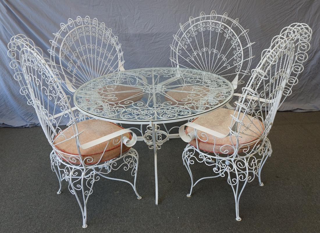 5 PC SALTERINI MID CENTURY PATIO SET: Classic Salterini Mid Century Patio Set. With four matching ornate wrought iron twisted wire fan peacock back patio chairs and glass topped table. These chairs are handcrafted from wrought iron. Decor