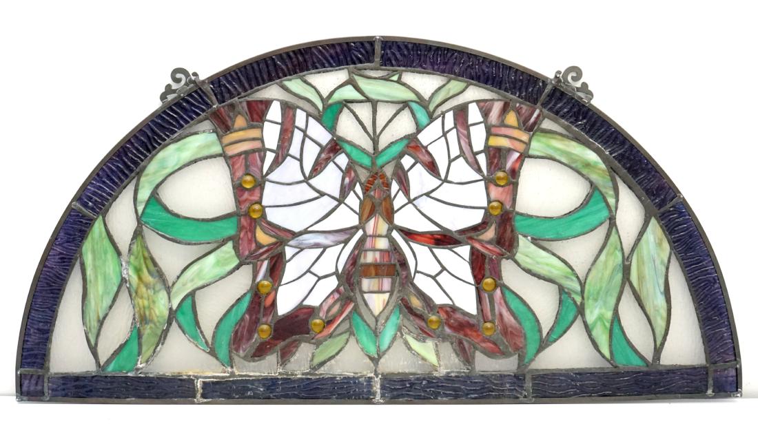 STAINED + LEADED GLASS BUTTERFLY PANEL: Hand crafted 20th c. American Stained and Leaded Glass Butterfly Panel of Demi Lune Form depicting Butterfly and Florals. . Measures 24"x12 1/4". Weight 3 pds. PROVENANCE: A Charleston SC Private Esta