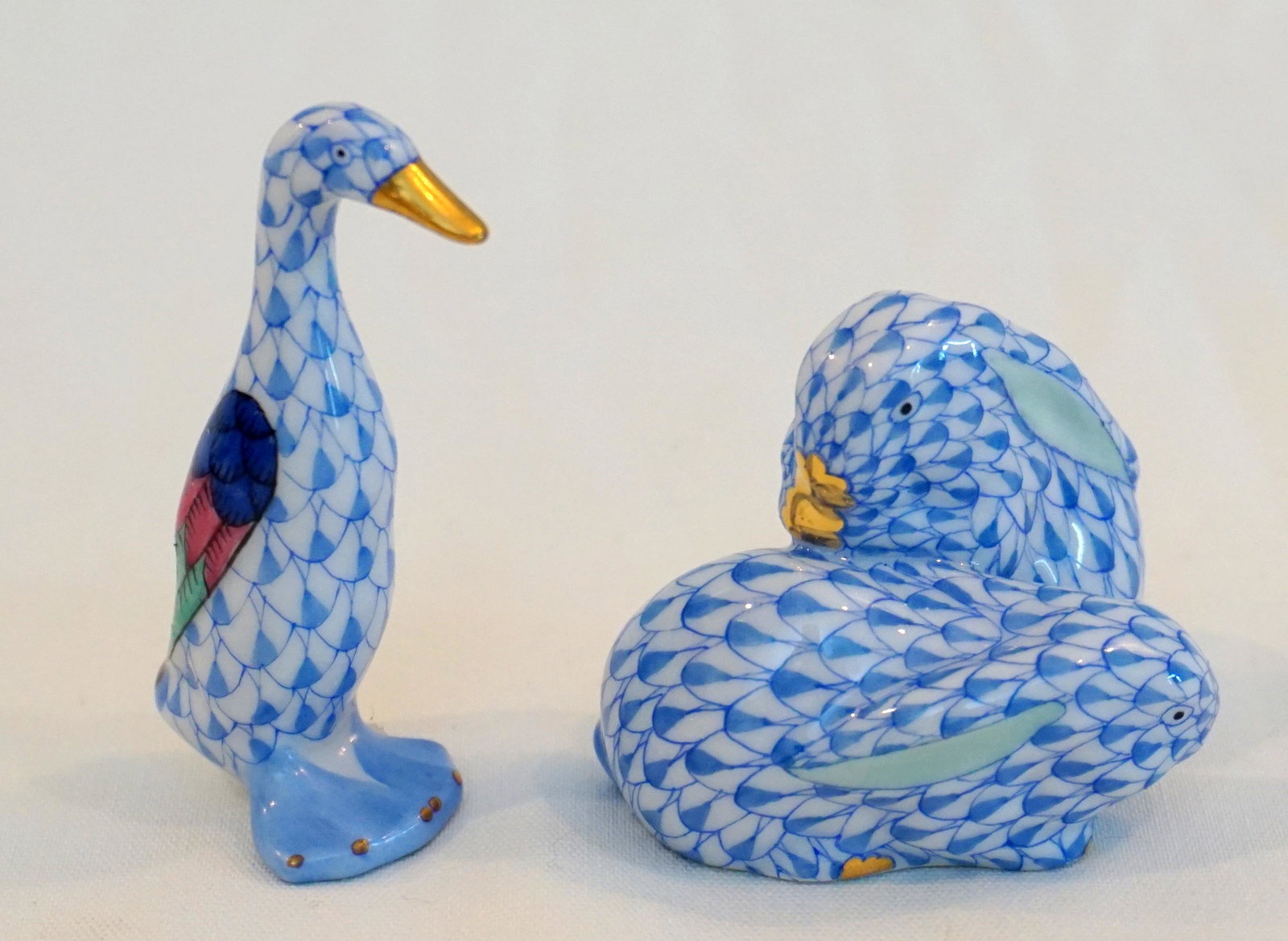 2 pc HEREND DUCK & RABBITS: 1- Pair of Rabbits – Small are painted in Vieux Herend (VHP) Blue Fish Scale design. 2"x1 1/2"x1 1/2". 2- Small Duck is painted in Vieux Herend (VHR) Blue Fish scale decor. 1"x1"x2 1/2". The fishnet
