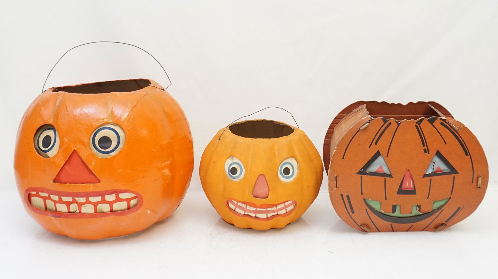 3 VINTAGE CARDBOARD HALLOWEEN JACK-O-LANTERNS: Three Vintage 1940s Cardboard Jack O Lanterns. All are cardboard with paper insert. Perfect for October. Largest 8"x7 1/4", One at 8"x6 1/4" and One at 6"x5 1/4". Weight 1 pd 2 oz. PROVENANCE: A Priva
