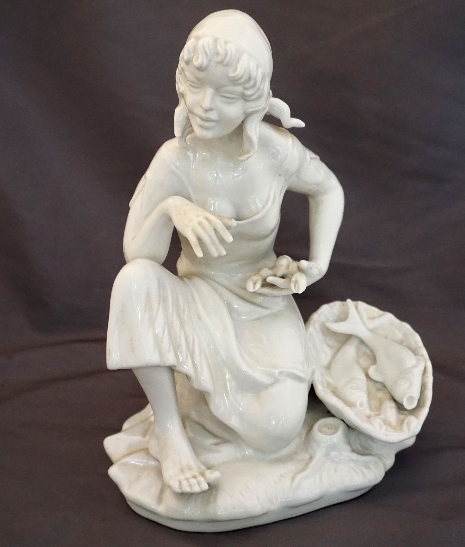 DRESDEN PORCELAIN WOMAN WITH FISH: Dresden Figural White Porcelain, Woman with basket of fish. The Fishmonger Marked on base "Dresden" with "N' mark and crown. Measures 7 1/2"x5 3/4"x10". Weight 3 pds. Good condition. PROVENANCE: A Pri