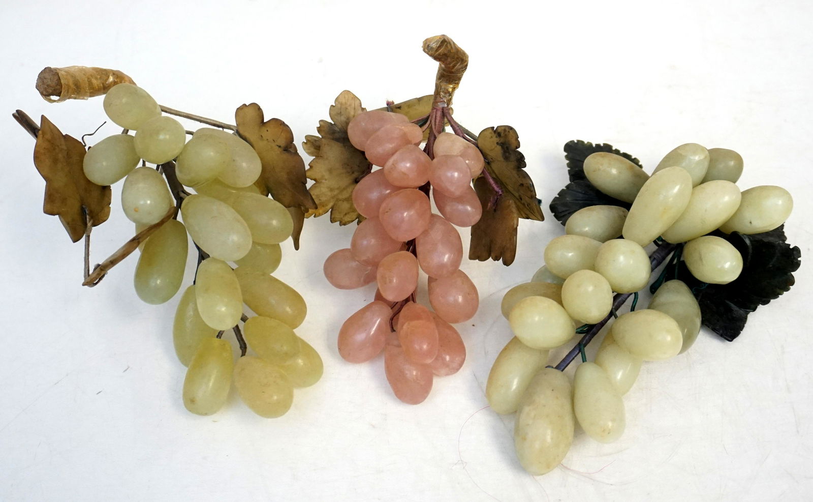 3 CHINESE JADE AND HARD STONE GRAPE CLUSTERS: Three Vintage Mid Century Chinese Jade and Hard Stone Grape Clusters. One is a rose quartz cluster. Longest 7 1/2". Weight on all 3 pds 5 oz. PROVENANCE: A Private Charleston SC Estate