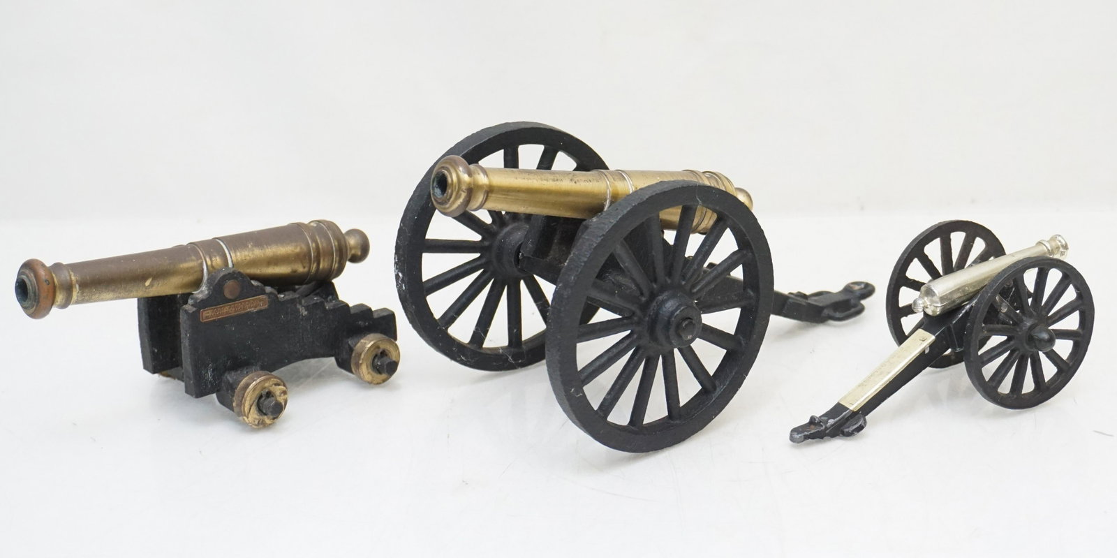 3 VINTAGE CAST IRON BRASS TOY CANNONS: 3 Vintage Toy / Souvenir Brass / Cast Iron Cannons. The largest with cast iron base and wheels 8" long. The medium with cast iron base from Fort Frederica National Monument 5 1/4" long and the smalles