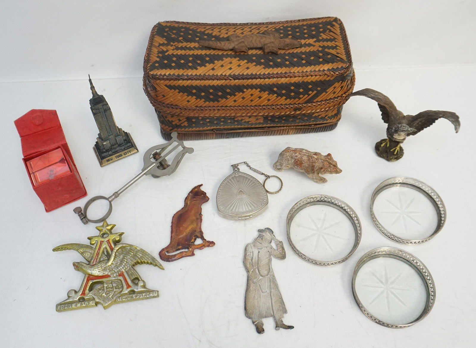 CROCODILE BASKET WITH TREASURE: Crocodile woven reed box with Wood Crocodile on top. Inside a Mr. Squeers Dickens Sterling Bookmark 4 1/4". 3 sterling and glass coasters. Vintage Anheuser Busch Logo Metal Emblem Car Ornament 4 1/2"x