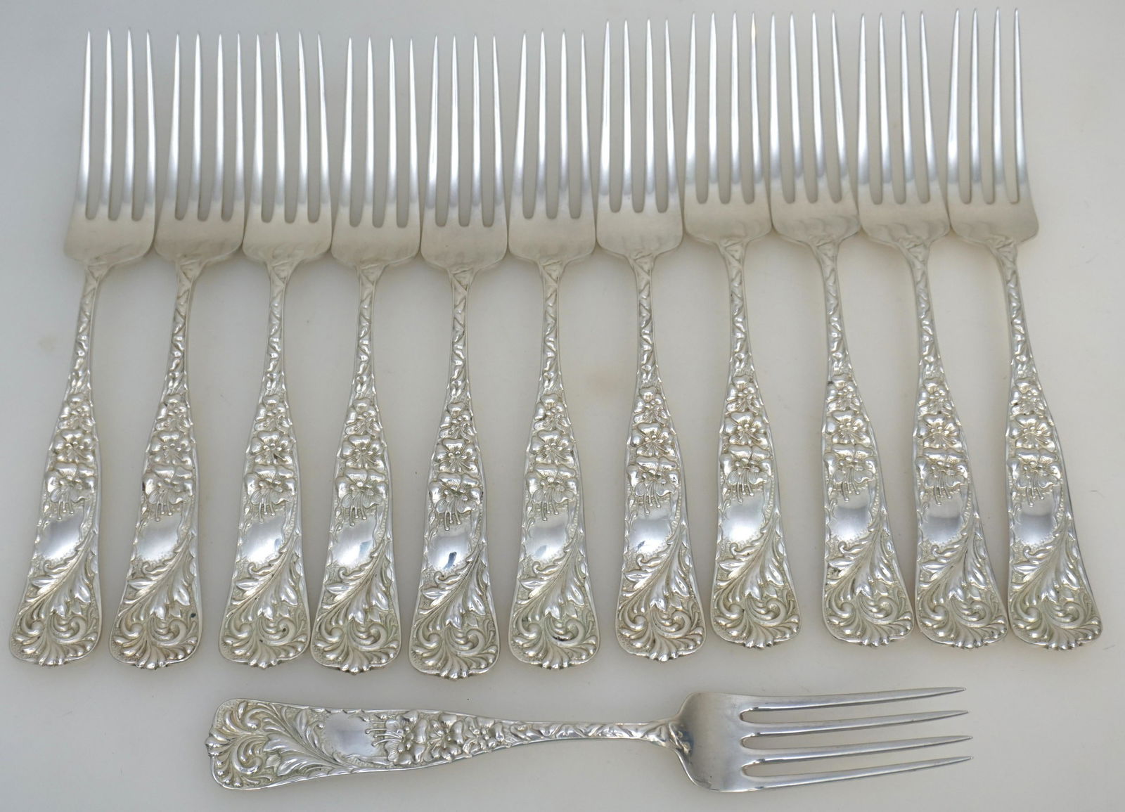 12 AMERICAN STERLING ORNATE FORKS: Twelve American Aesthetic Antique Sterling Silver Ornate Feather Plume and Lily Salad Forks. Retailed at James McCaffrey Jewelers in Philadelphia. Ornate Repousse. No monograms. Each 6 3/4". Weight ap