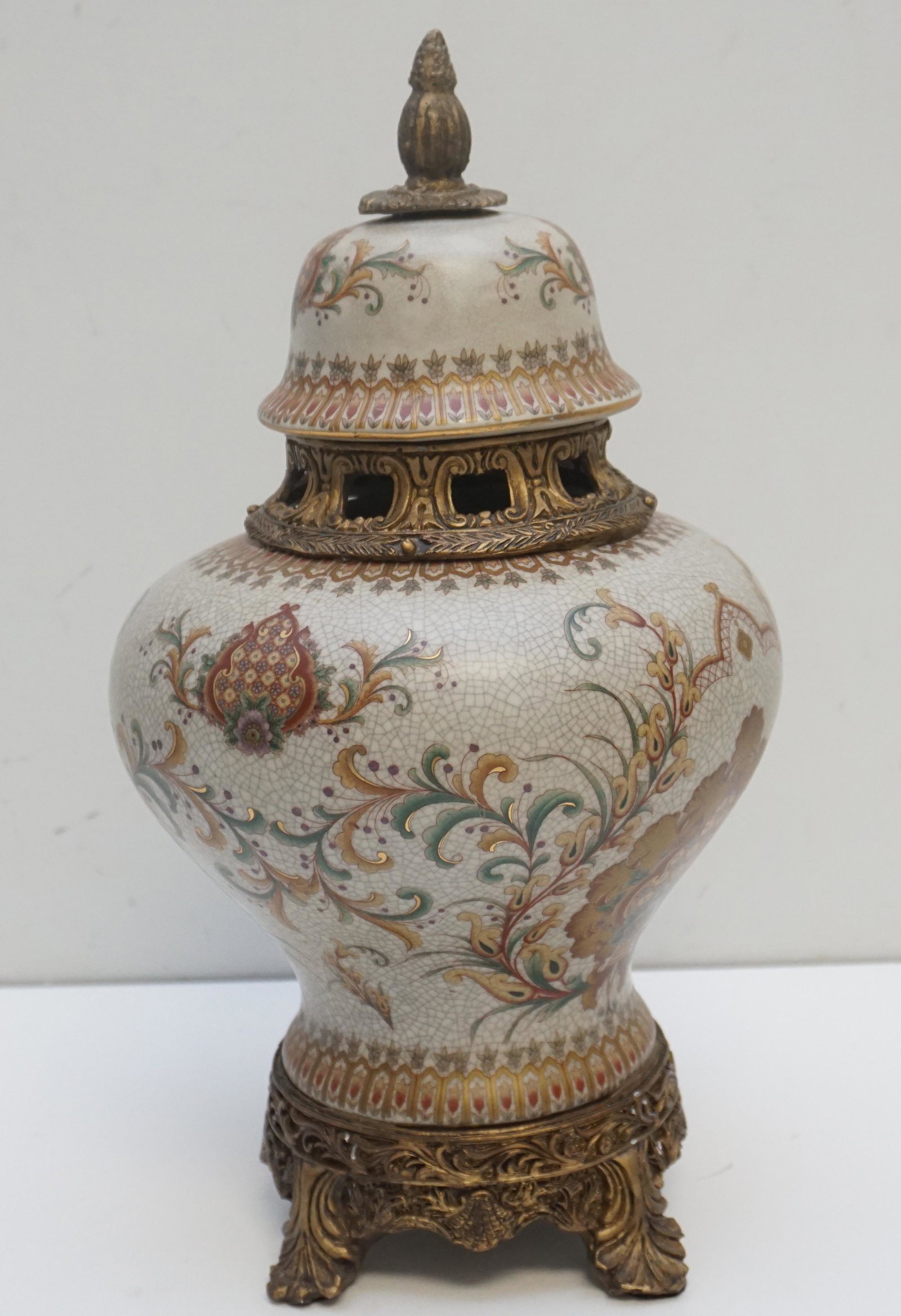 ORMOLU MOUNTED PORCELAIN JAR: Vintage Ormolu Mounted Porcelain Lidded Jar in the French Style. The entire jar is porcelain with the foot and neck composite painted in a bronzed gilt to resemble metal. The jar is floral and geometr