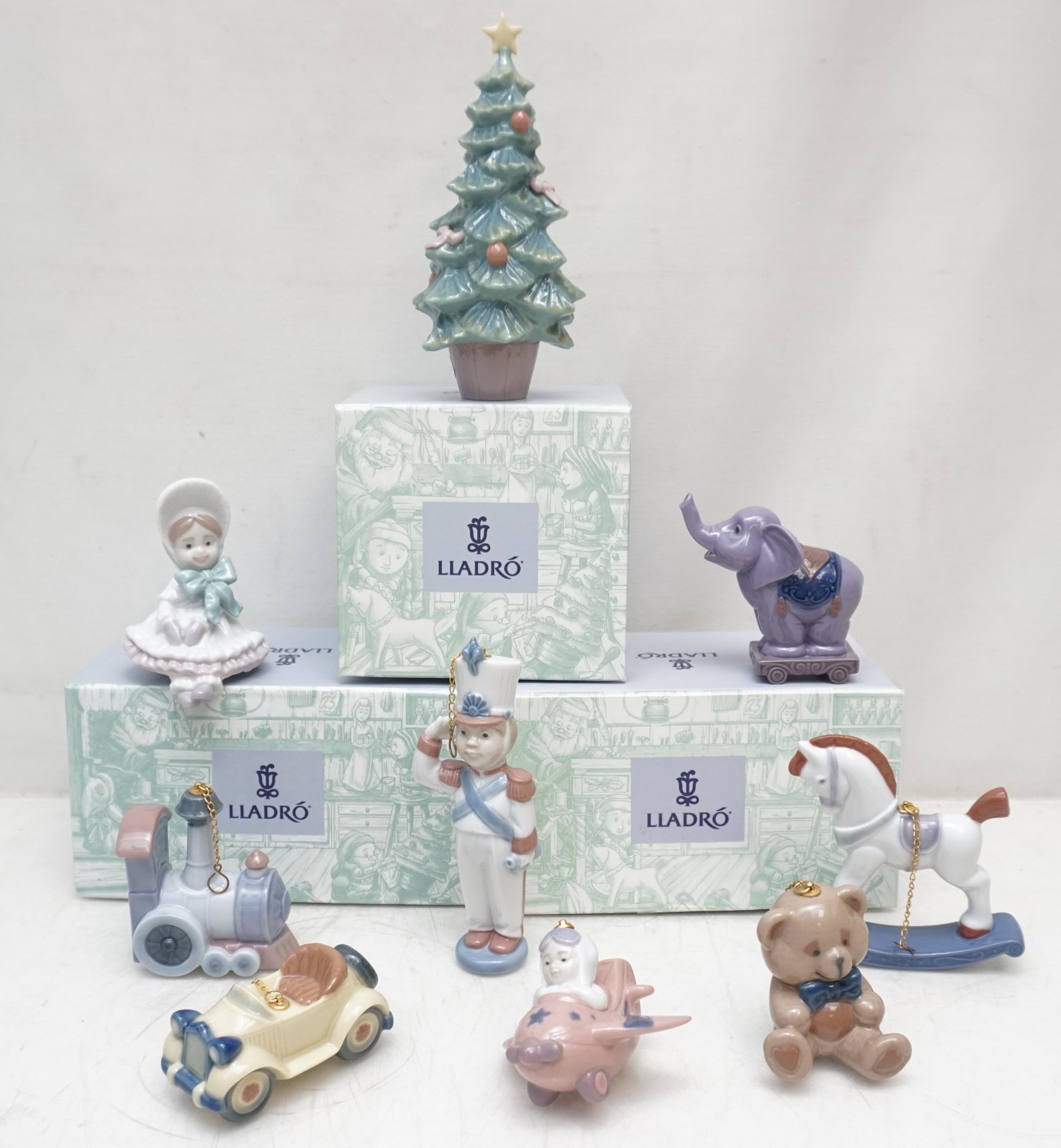 9 LLADRO SANTAS WORKSHOP PORCELAIN: Nine Lladro Porcelain Santas Workshop Porcelain Ornaments. All with original boxes. 1- Christmas Tree #6261. 2- Toy Soldier 6345. 3- Circus Star 6388. 4- Little Aviator #6343. 5- Teddy Bear #6344. 6- 