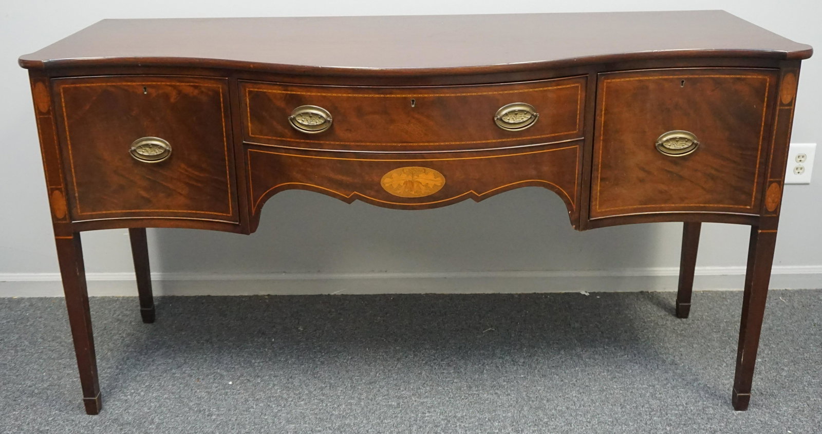MAHOGANY INLAID HEPPLEWHITE STYLE SIDEBOARD: Hepplewhite Style Mahogany Inlaid Sideboard. Early 20th century c. 1900-1910, mixed wood inlays,bowfront form, case featuring three drawers, two deep drawers on sides with sliding lift out flatware ca