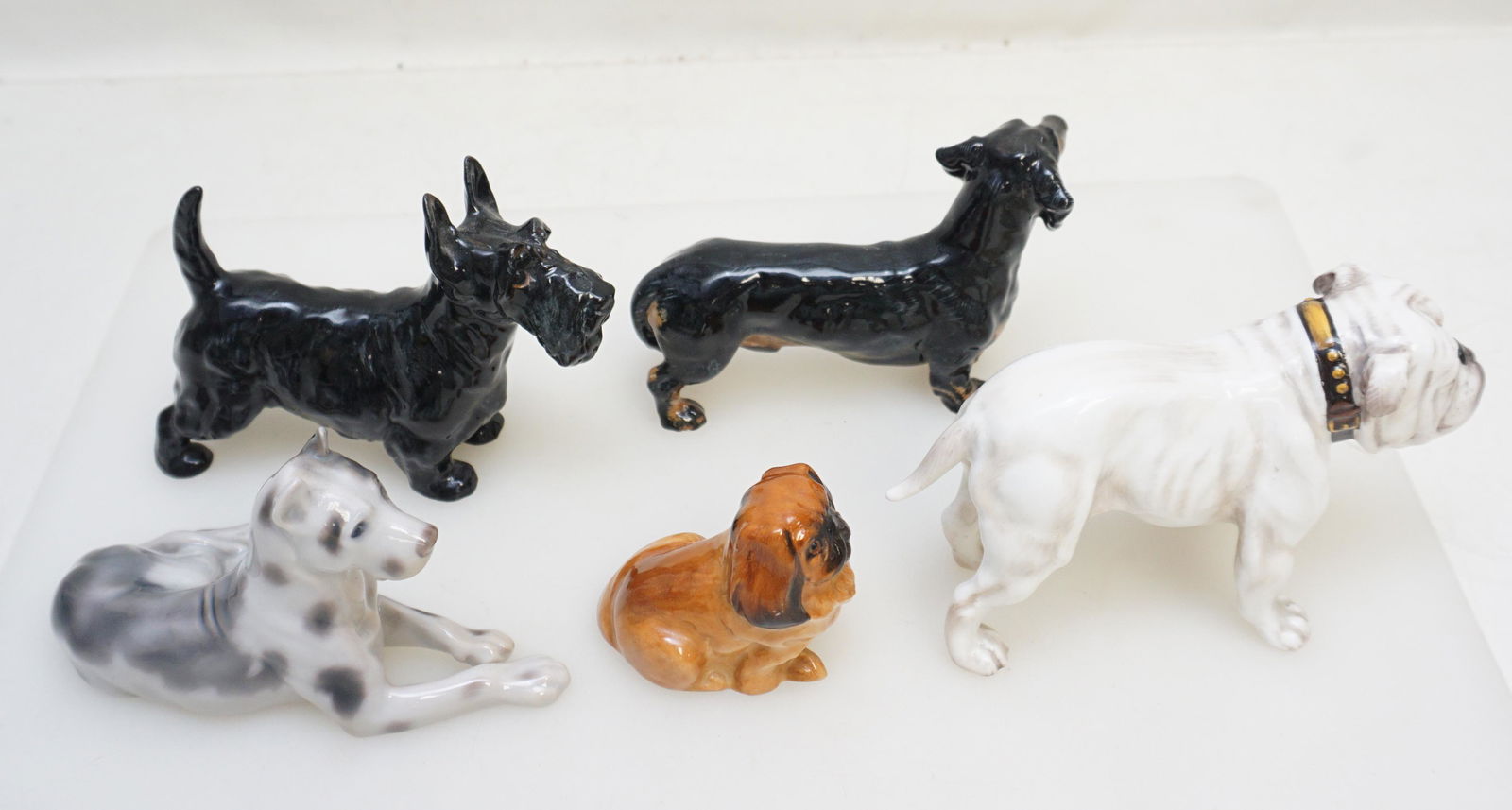 5 ROYAL DOULTON DOGS BULLDOG - PEKE +: 4 Royal Doulton Dog Figurines and 1 Bing & Grondahl. 1- Bing & Grondahl Great Dane 5" long. 2- Royal Doulton Bulldog HN 1074 5 1/2" long. 3- Royal Doulton Scotty 1016 5" long. 4- Royal Doulton Dachshu