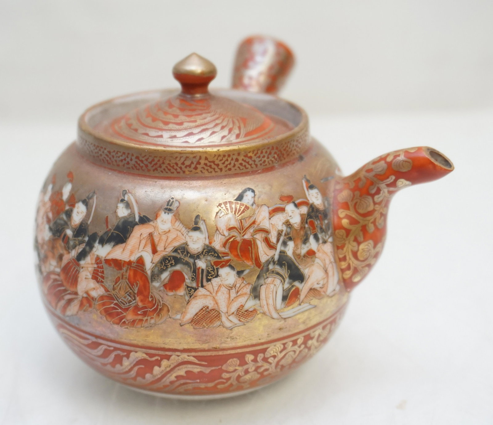 JAPANESE KUTANI PORCELAIN KYUSU: Antique Early 20th c. Japanese Kutani Kyusu porcelain small teapot and lid, in orange, red with lots of gilt decoration. Measures 4"x3 1/2". Weight 5 oz. PROVENANCE: The Estate of Dr. Fraser Wilson, C
