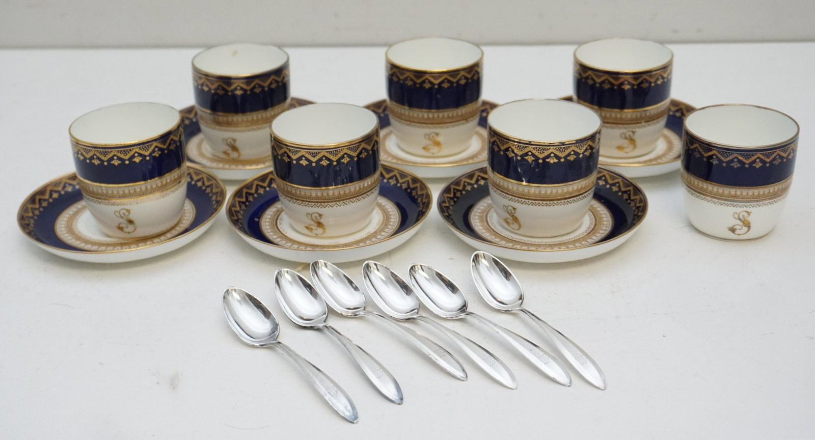 19TH c. ENGLISH DEMITASSE SET: Antique 19th c. English William Brownfield & Son Demitasse Set. Cobalt and Gilt. 7 Cups, all monogrammed with a gold "S", one with old staple in bottom to repair hairline. 6 Saucers, 1 with chip to ri