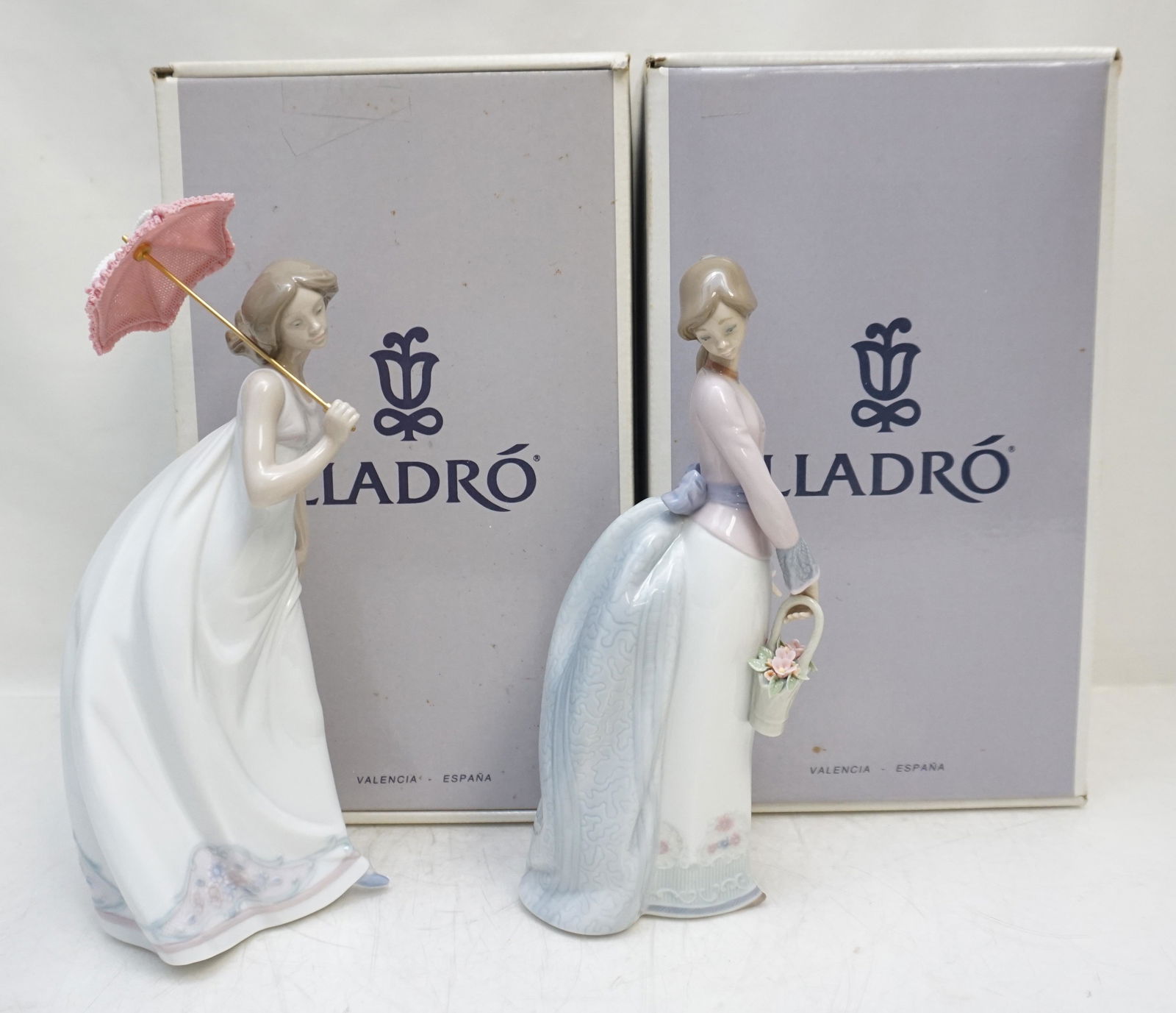 2 LLADRO PORCELAIN FIGURINES: Both in the Original Boxes. 1- Basket of Love #7622. Issued 1994, Retired 1996. Figure 9 3/4". Box 12 1/2"x7 1/2"x6". 2- Afternoon Promenade #7636. Retired 1998, Figure 11". Box 12 1/2"x7 1/2"x6". Gre