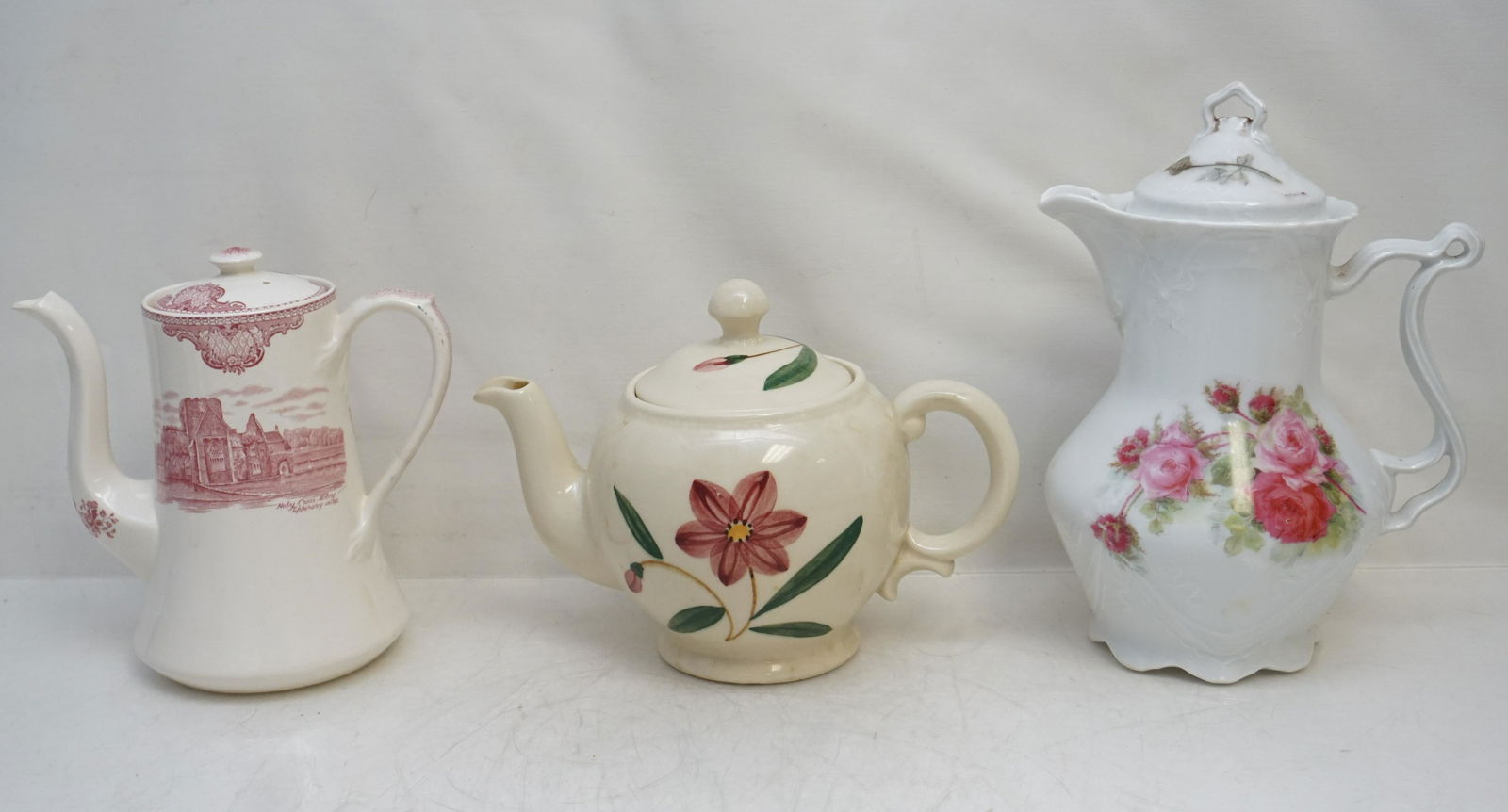 3 ANTIQUE / VINTAGE CHOCOLATE - COFFEE - TEA: 1- German Porcelain Chocolate Pot Pink Roses 9 3/4". 2- Johnson Brothers Britains Castles Coffee Pot 7 1/2". 3- Shawnee USA Pottery Teapot 7". Weight on all 4 pds 3 oz. PROVENANCE: A Charleston SC Pri