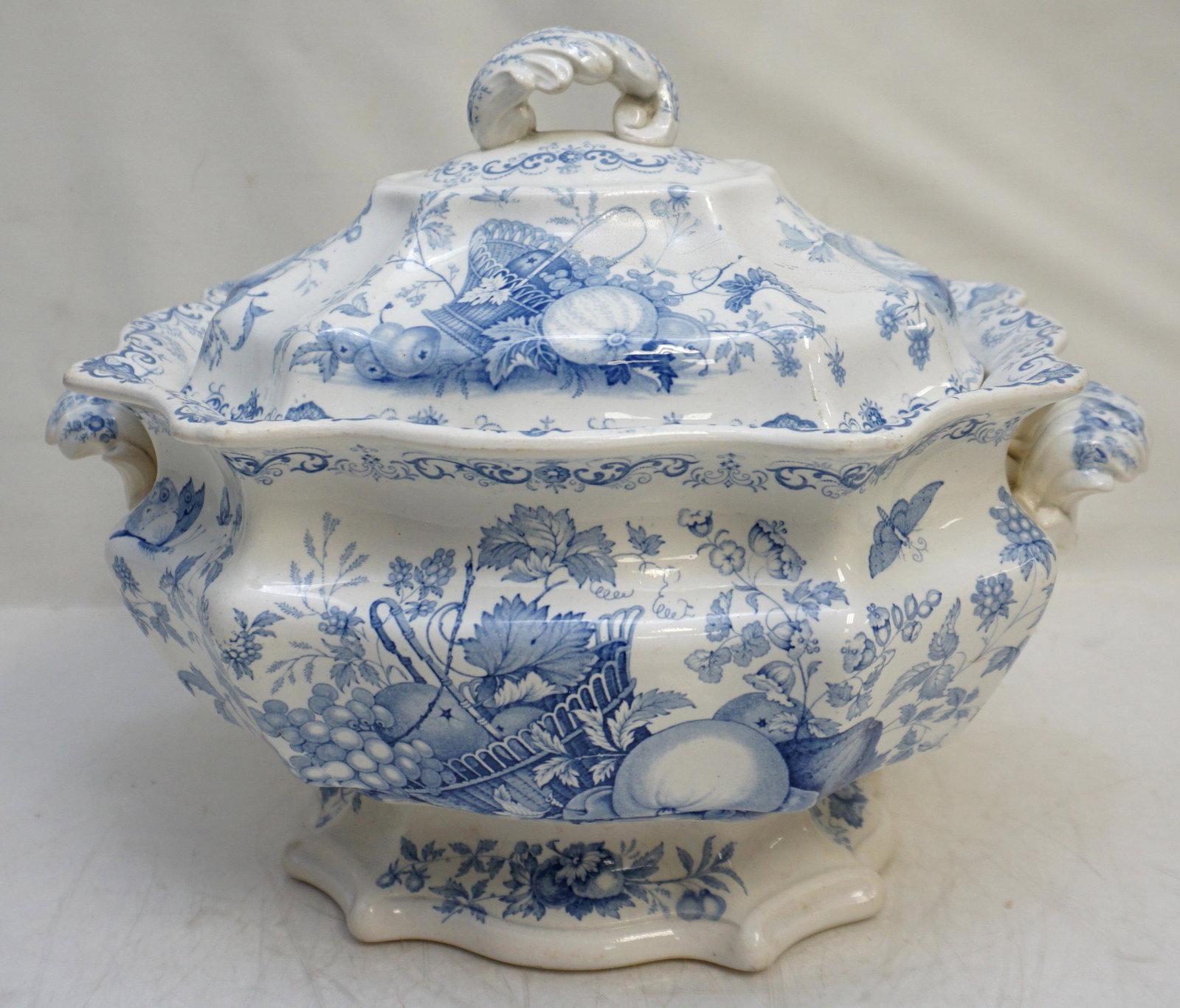 ANTIQUE FRUIT BASKET TUREEN: Antique English Ironstone "Fruit Basket" Footed Soup Tureen. Blue and White. Old professional repair to lid. Measures 13"x9"x10". Weight 5 pds 4 oz. PROVENANCE: The Estate of Dr. Fraser Wilson, Charle