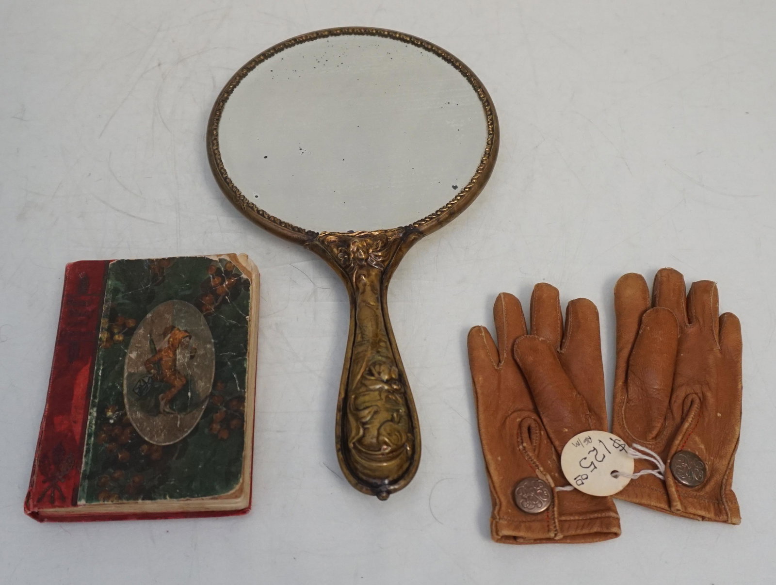 3 pc VICTORIAN CHILDS LOT: 3 Piece Victorian Childs Lot. 1- Soft Childrens Kidskin Gloves, Brass Buttons Made in Germany. 2- Art Nouveau Hand Painted Cherry Porcelain Beveled Hand Mirror with Brass Mermaid Repousse Handle 9 1/4