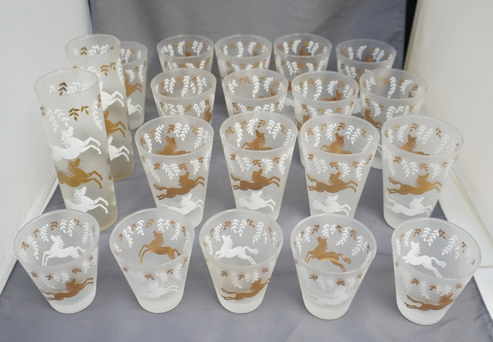 20 PC MID CENTURY 1953 LIBBEY CAVALCADE: 20 Mid Century Stemware Pieces of Libbey 1953 "Cavalcade", White & Gold Horse Frosted Glasses. All in good condition. 1- Two 7" Coolers / Tom Collins. 2- Fifteen Tumblers 4 3/4" tall and 3 1.4" across
