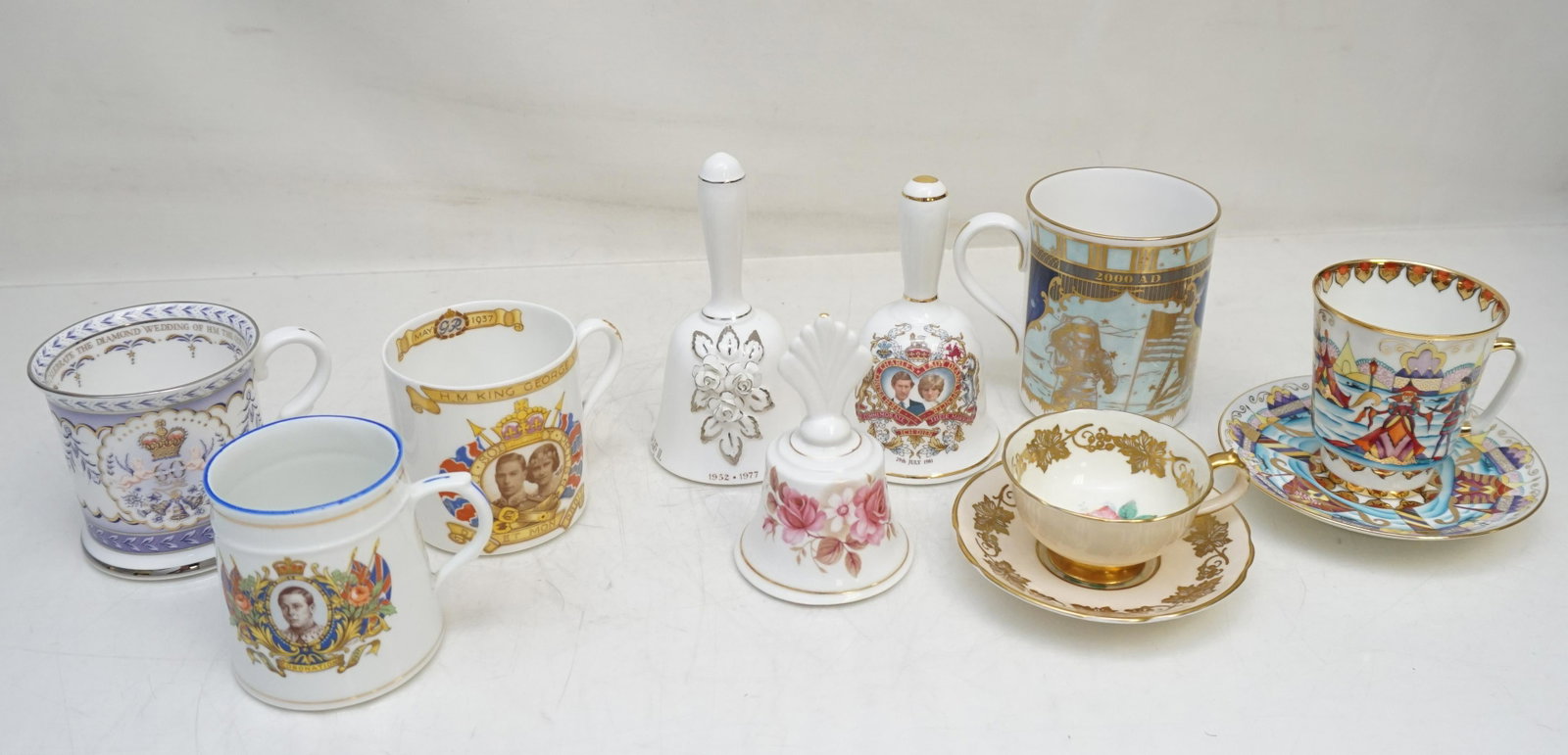 9 PORCELAIN & ROYAL COLLECTIBLES: 1- H.M. King George 1937 Coronation Mug. 2- H.M. King George 1937 Coronation Mug. 3- The Diamond Wedding Jubilee The Queen 2007 Mug. 4- Charles & Diana Wedding Bell 1981. 5-Silver Jubilee Queen Elizab