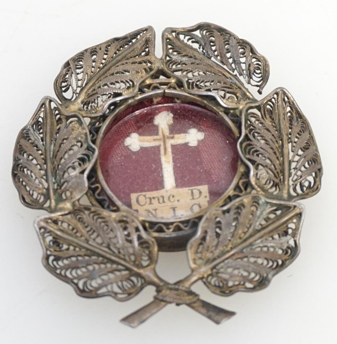 CATHOLIC RELIQUARY PAPAL SEAL: Antique Catholic Reliquary of the True Cross. Cruc. D. N.I.C. in a Silver Filigree Pendant Case under Glass, with the original Vatican seal and wax strings intact. Measures 1 3/4". PROVENANCE: A NYC /