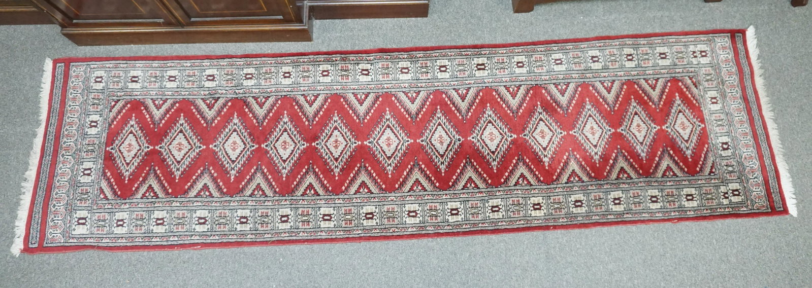 HAND KNOTTED WOOL BOKHARA RUNNER: Good Quality Hand Knotted Bokhara Rug, 100% Wool. Measures 116"x31, Pakistani, repeating rows of guls on central panel, multiple borders. Excellent condition. Weight 10 pds. PROVENANCE: A Charleston S