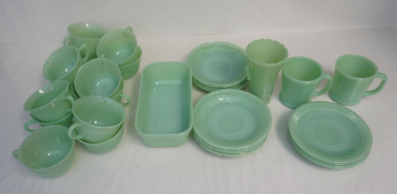 30 PIECE JADEITE FIRE KING: Thirty Pieces of Vintage Fire King Jadeite. Includes 9 cups and 9 saucers in the Alice Pattern, 4 cups and 4 saucers in the Jane Ray pattern. 2 Coffee Mugs. 1 Refrigerator Dish. All are Fire King. In
