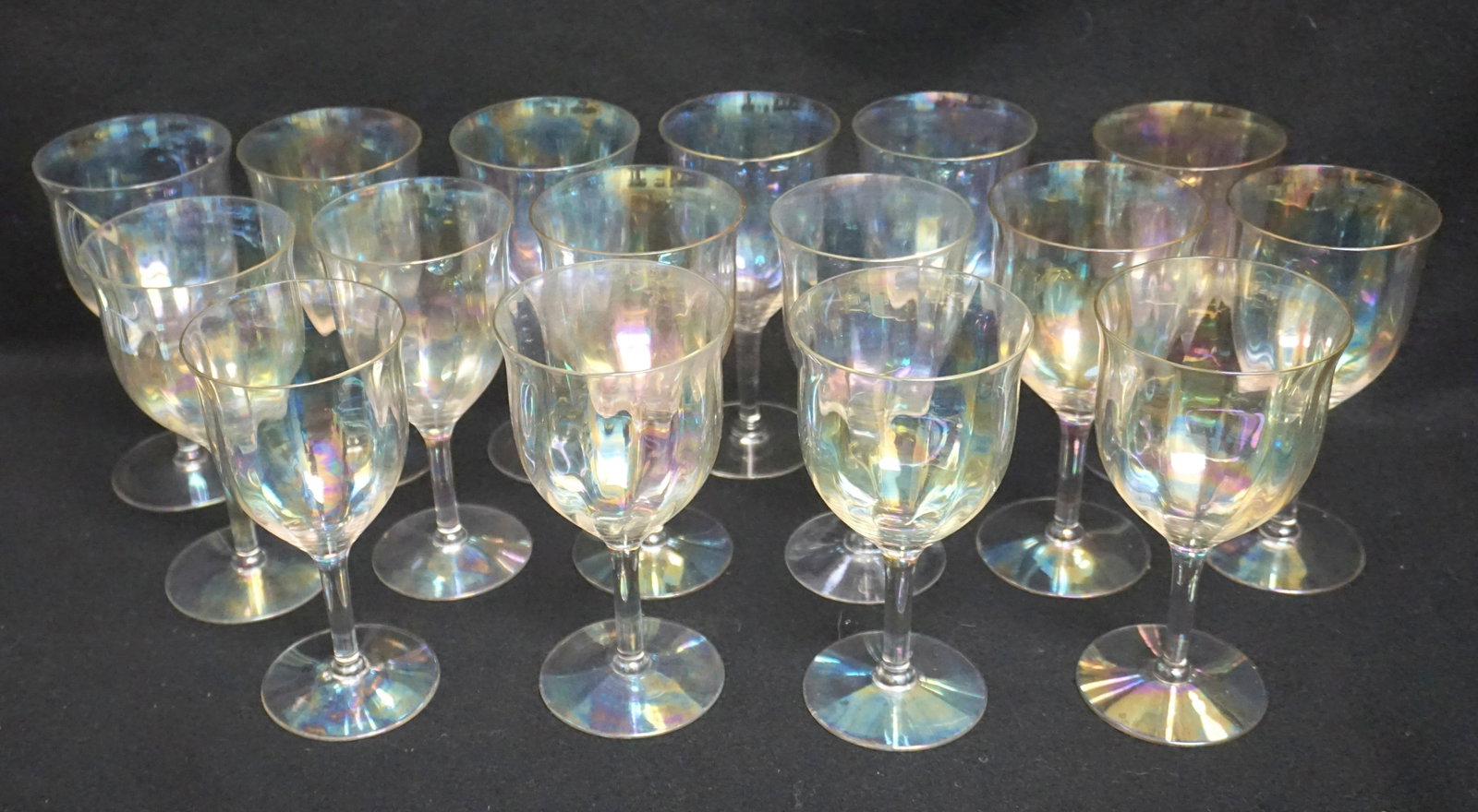 16 IRIDESCENT WINE GLASSES: Sixteen (16) Art Deco 1930s Fostoria iridescent rainbow colored wine glasses with optic rib design and fluted tops. Approximately 6 1/2" tall. Weight on all 4 pds 12 oz. PROVENANCE: A Charleston SC Pr