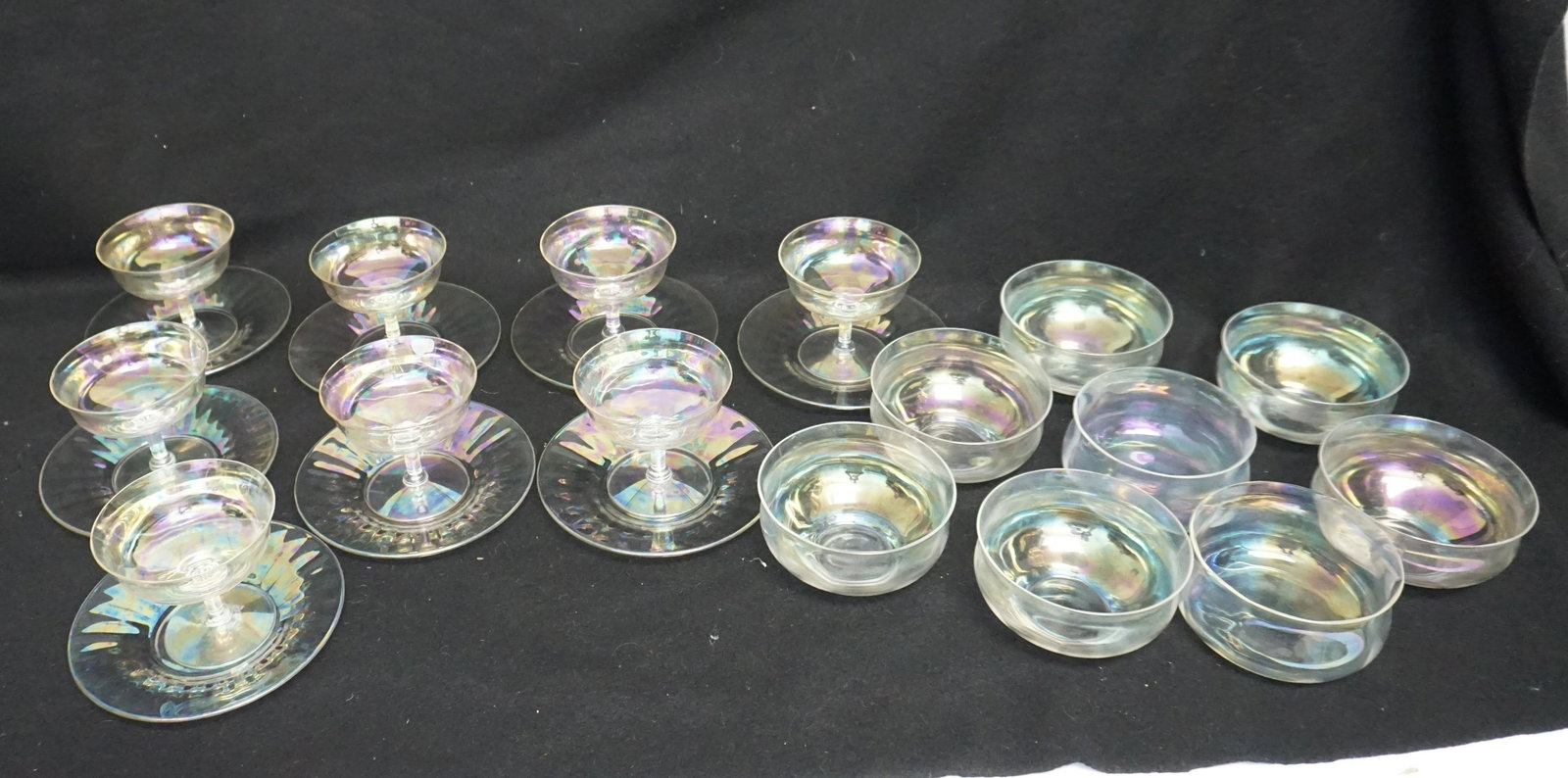 24 PC ART DECO IRIDESCENT GLASS: 24 Piece Vintage Art Deco Iridescent Glass. 8 Fluted Iridescent Pearlescent Champagne Coupe / Cocktail / Dessert Glasses 3 3/4" wide and 3 1/2" tall. 8 Fluted Iridescent Pearlescent Underplates / Sauc