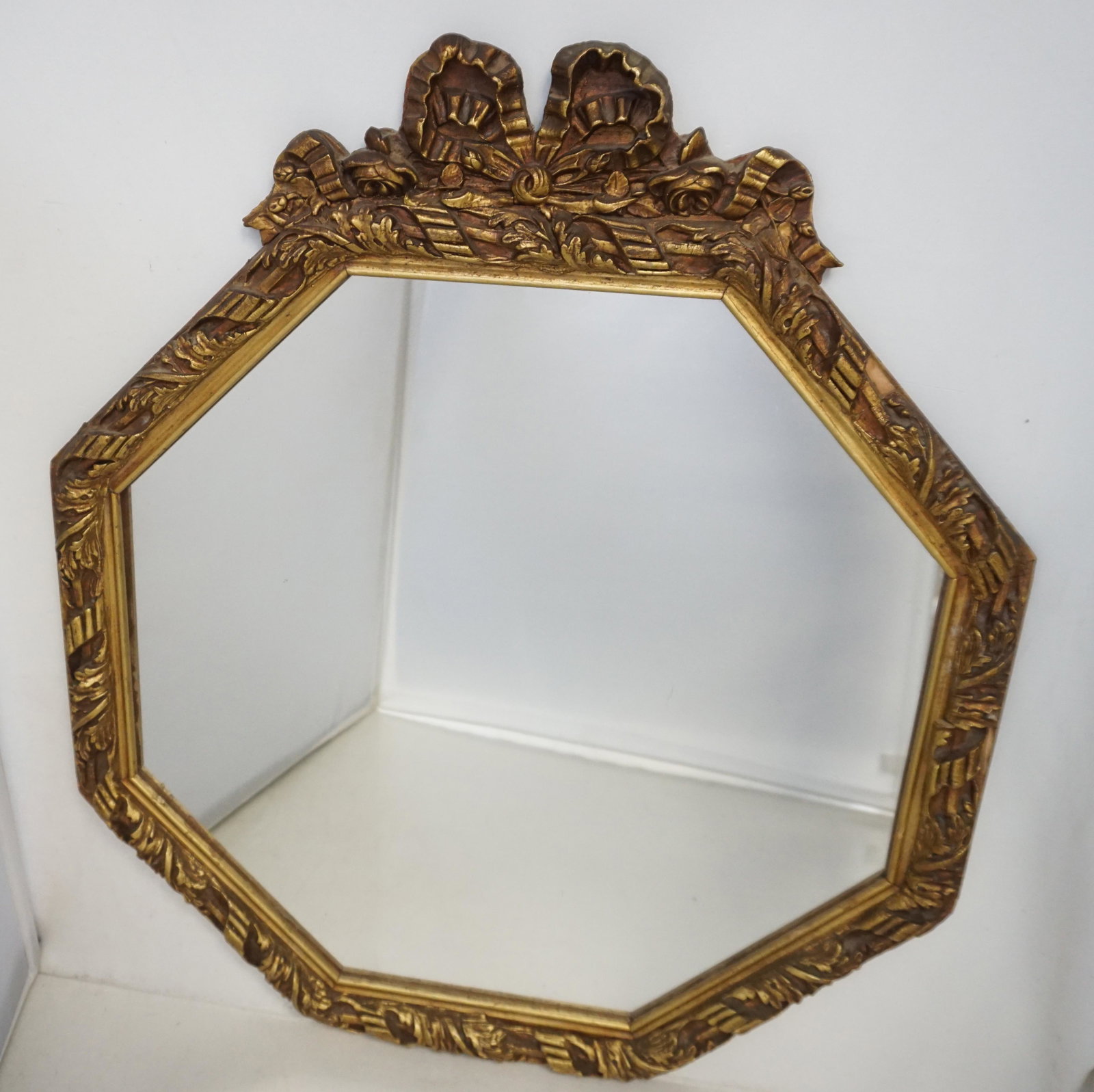 ANTIQUE GILT OCTOGONAL MIRROR: Antique Carved Wood and Gilt Gesso Mirror. Octogonal Shape with replaced mirror. Minor wear and one chip to frame. Measures 18 1/4"x21". Weight 4 pds 7 oz. PROVENANCE: A Private Charleston SC Estate. 