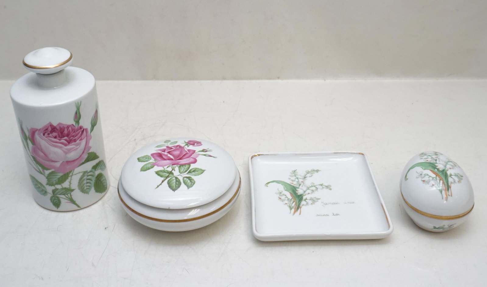 4 pc LIMOGES PORCELAIN VANITY: All are Vintage Limoges 1- Limoge Porcelain Rose Dresser / Powder Box 4 1/2". 2- Limoges Tall Cologne Bottle Rose 6 1/2". 3- Limoges Dresser Tray Lily of the Valley 5". 4- Limoges Egg Box, Lily of the