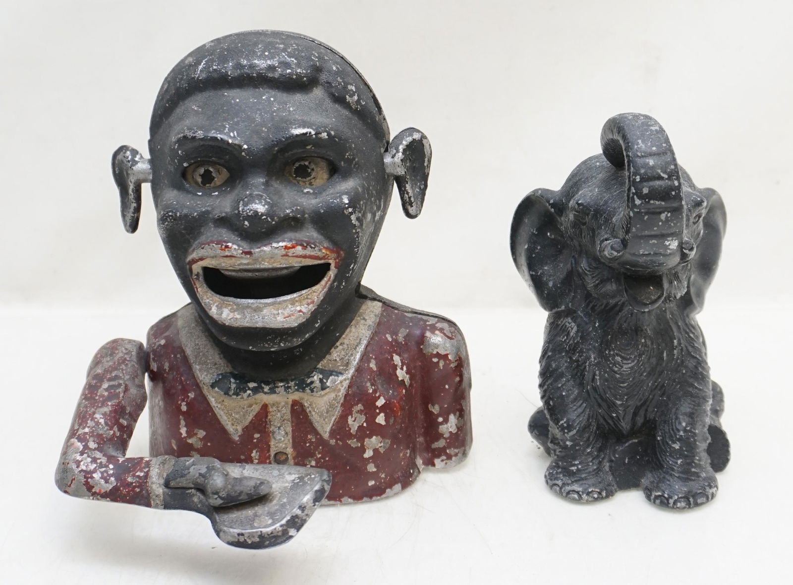 2 BANKS ELEPHANT & JOLLY N EARLY 20TH C: 1- Original Starkies Aluminum Jollie N. Bank. Depress lever to move arm and swallow coin, eyes roll and ears wiggle. Working. Base plate has square waffle type holes and is inscribed: "Reg. No 844,290