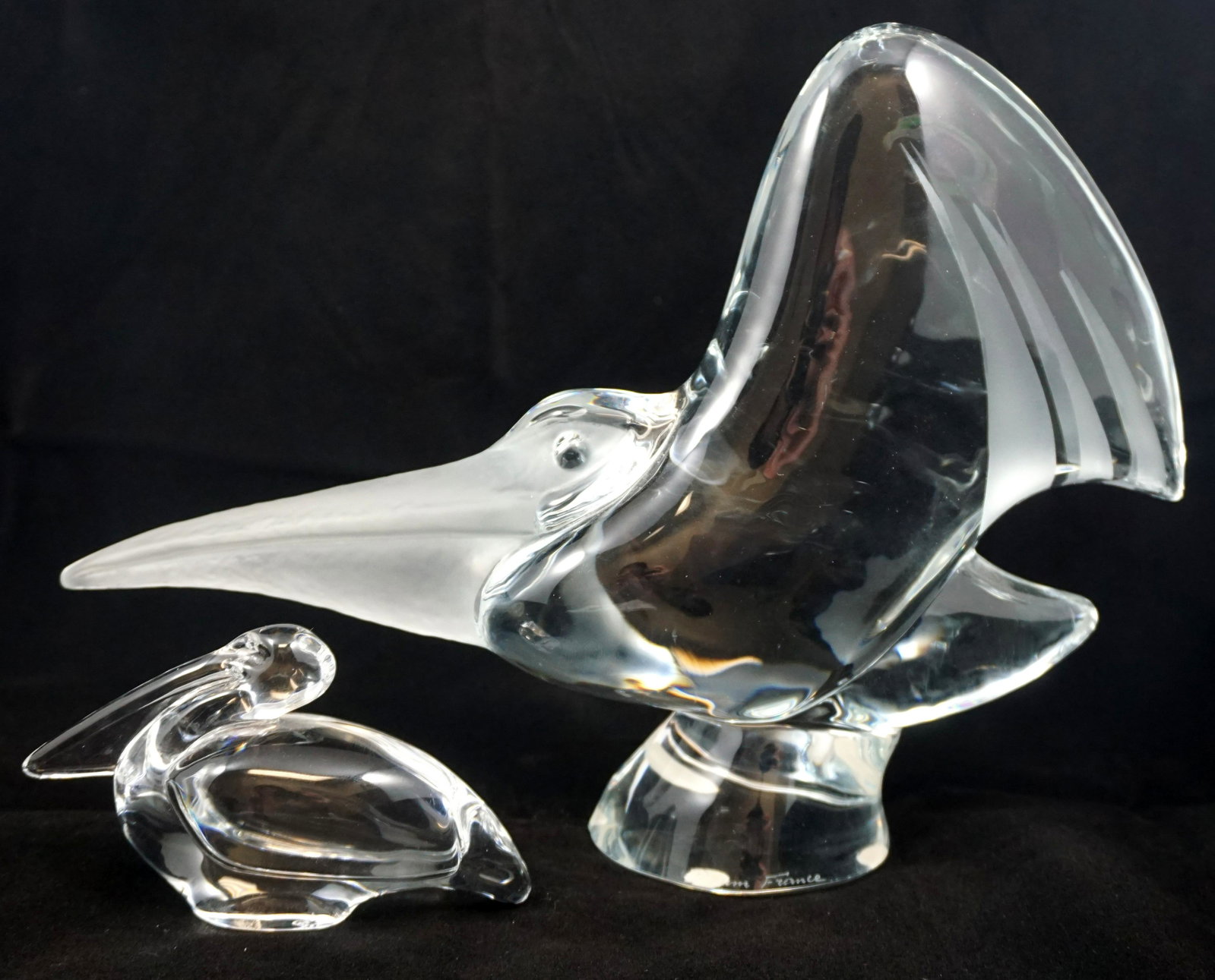 DAUM & BACCARAT PELICANS: 1- Signed 20th c. Daum Glass Pelican with frosted beak and feathers Engraved Daum, France 8 1/2" tall, 24" diameter. 2- Baccarat 20th c. Pelican Paperweight. Acid etched mark, 3" high. Weight combined