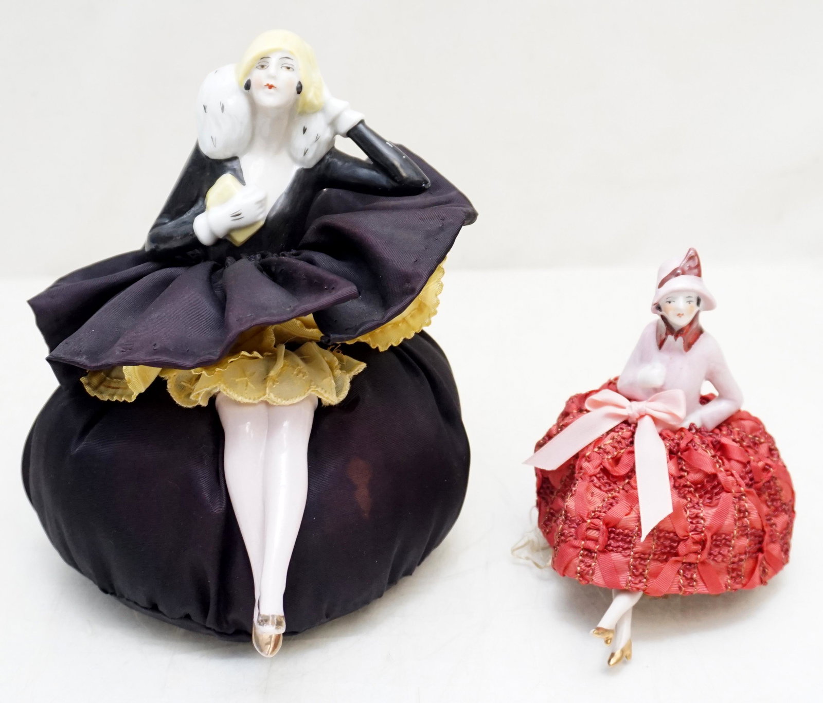 2 ART DECO GERMAN PORCELAIN PIN CUSHION: Two Art Deco German Porcelain Pin Cushions. Larger in Black and Yellow 5"x5"x7". Smaller in Pink and Red 2 1/2"x2 1/2"x4". Weight 9 oz. PROVENANCE: A Private Charleston SC Estate.