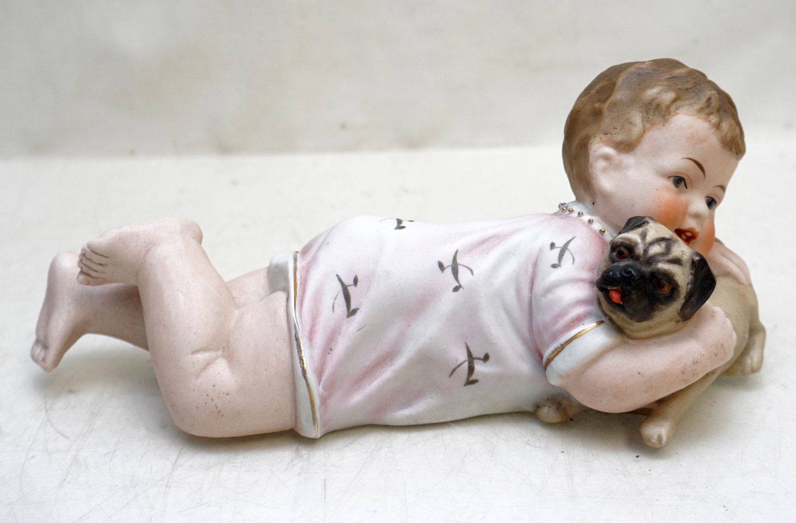 GERMAN BISQUE PIANO BABY WITH PUG: Antique German Bisque Porcelain Hand Painted Piano Baby with Pug c. 1900. Measures 9"x3 1/2"x4". Weight 12 oz. PROVENANCE: A Private Charleston SC Estate.