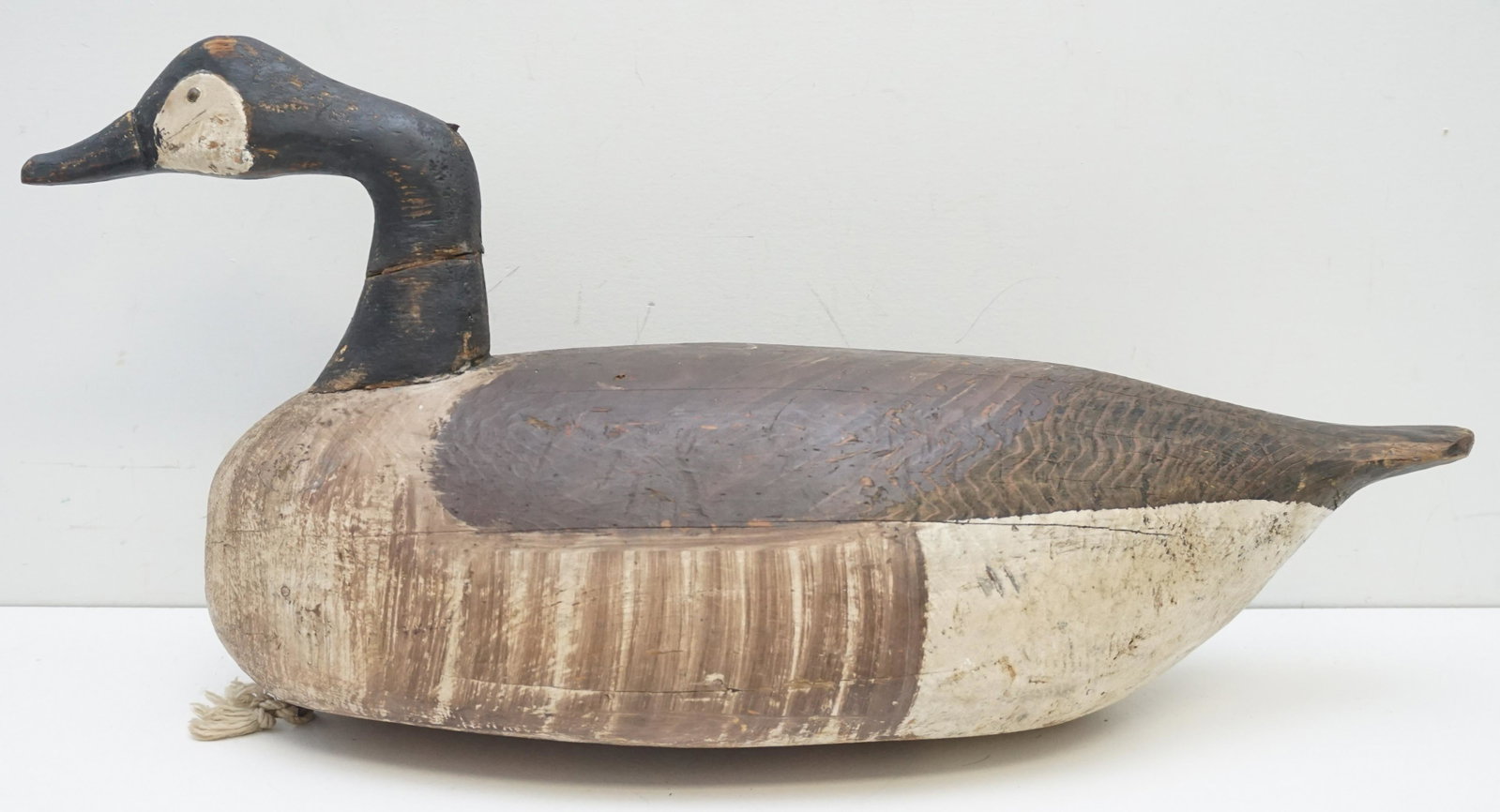 MILES HANCOCK HISSING CANADA GOOSE DECOY: Hissing Canada Goose working decoy, attributed to Miles Hancock, Chincoteague, Virginia, circa 1940's. Tack eyes, old paint, old weight, repair to neck. Measures 21"x7"x12". Weight 9 pds. PROVENANCE: 